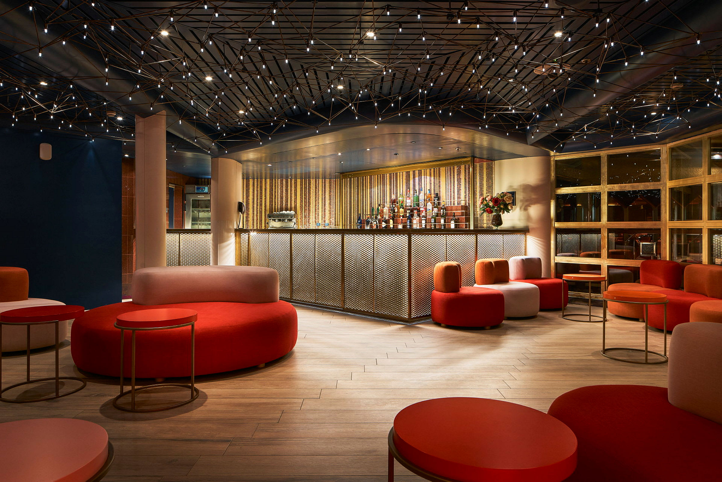 En modern bar med färgglada sittmöbler och en stilfull takdesign. (AI-genererad text)