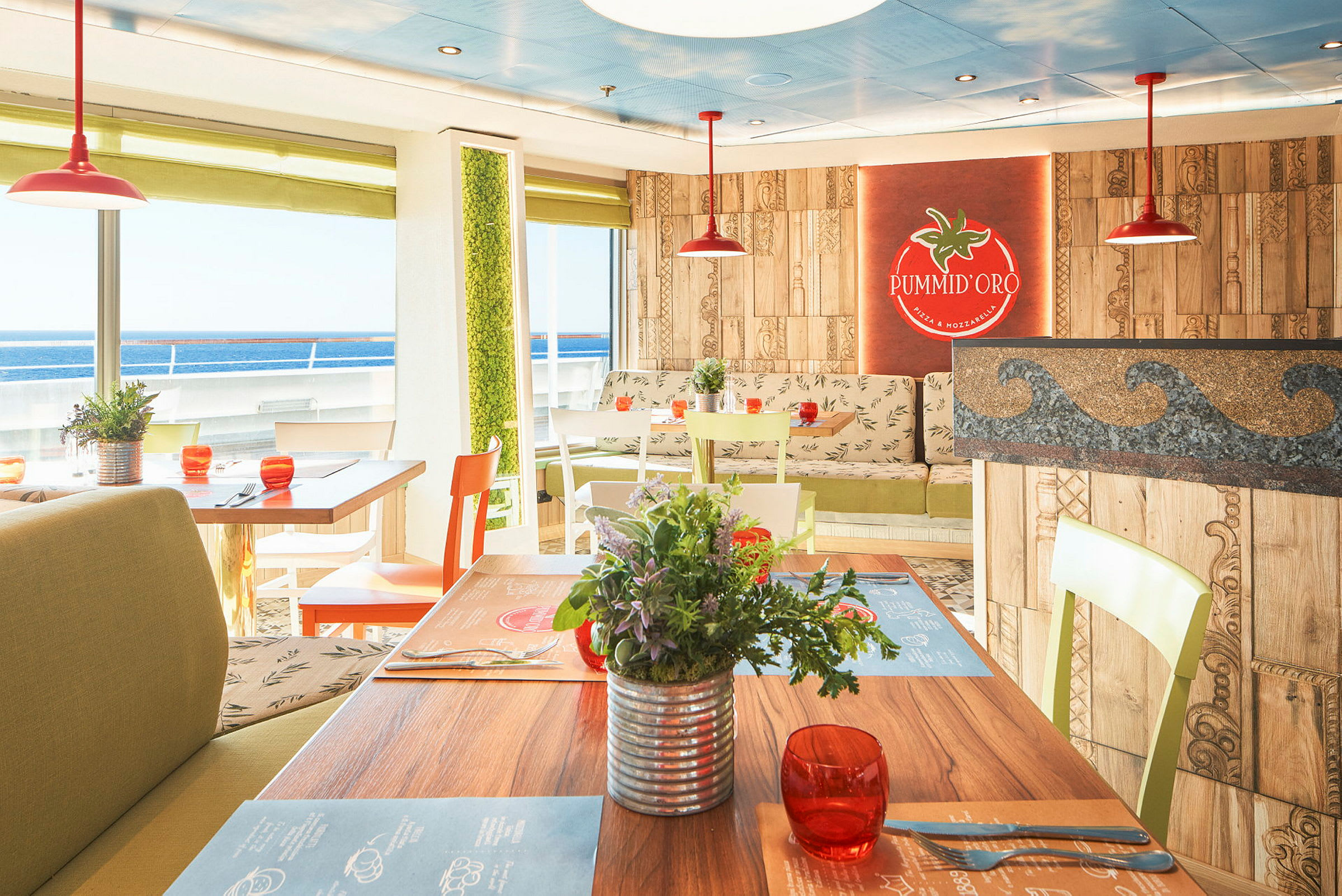 En ljus restaurang med bord, stolar och växter, samt utsikt över havet. (AI-genererad text)
