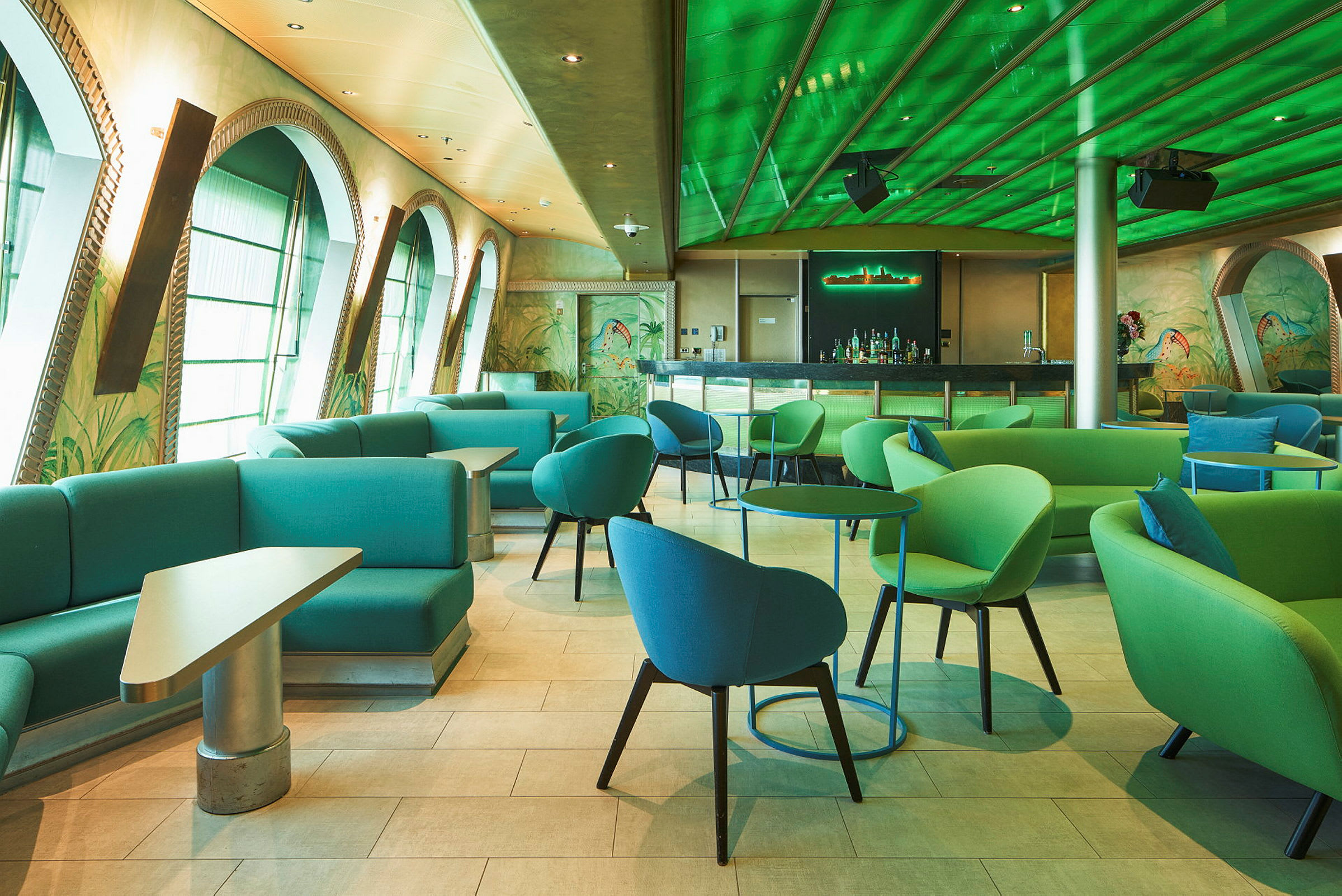 En modern bar med gröna och blå möbler och dekorativa fönsterbågar. (AI-genererad text)