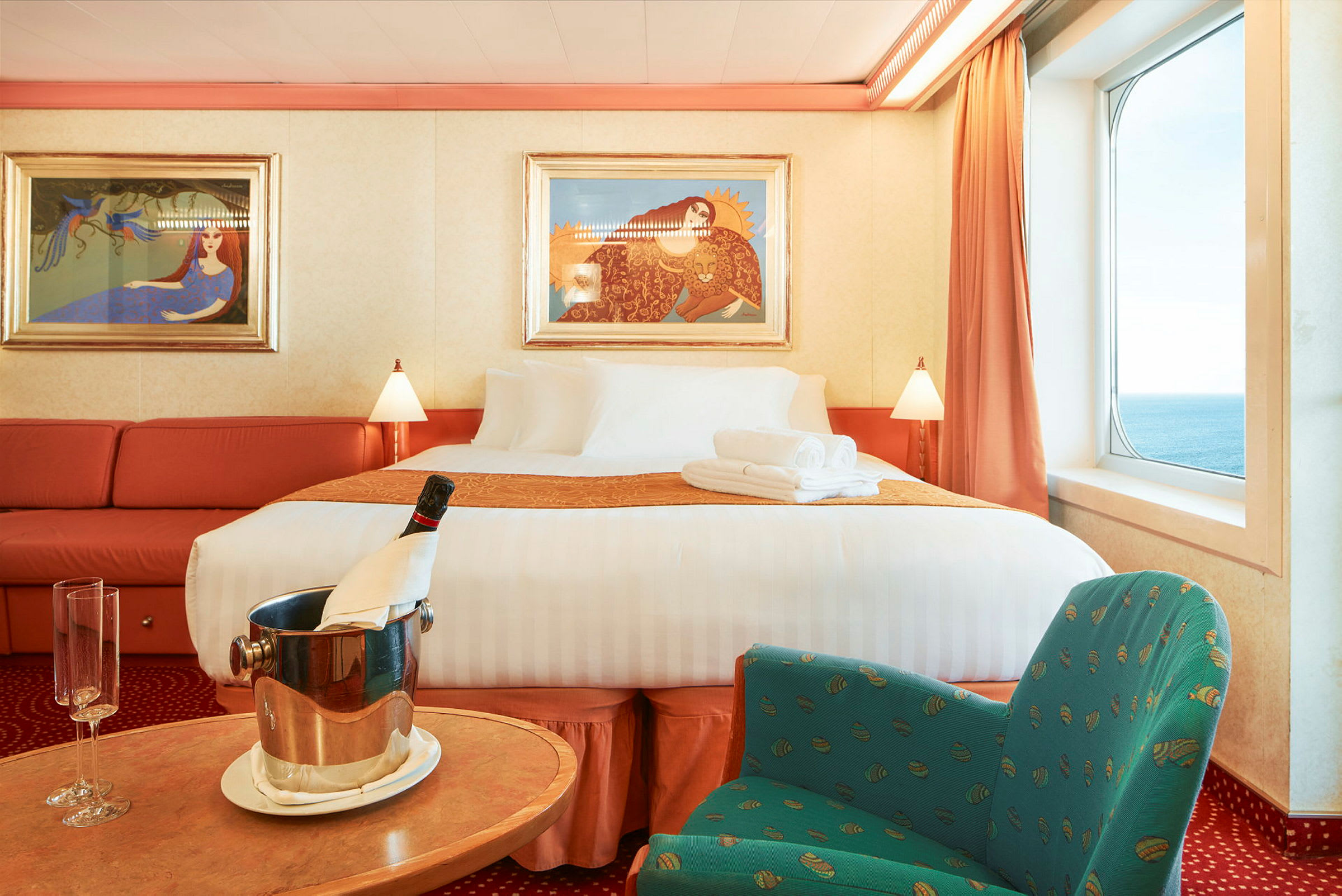 En lyxig hotellsvit med en stor säng, sittgrupp och havsutsikt. (AI-genererad text)