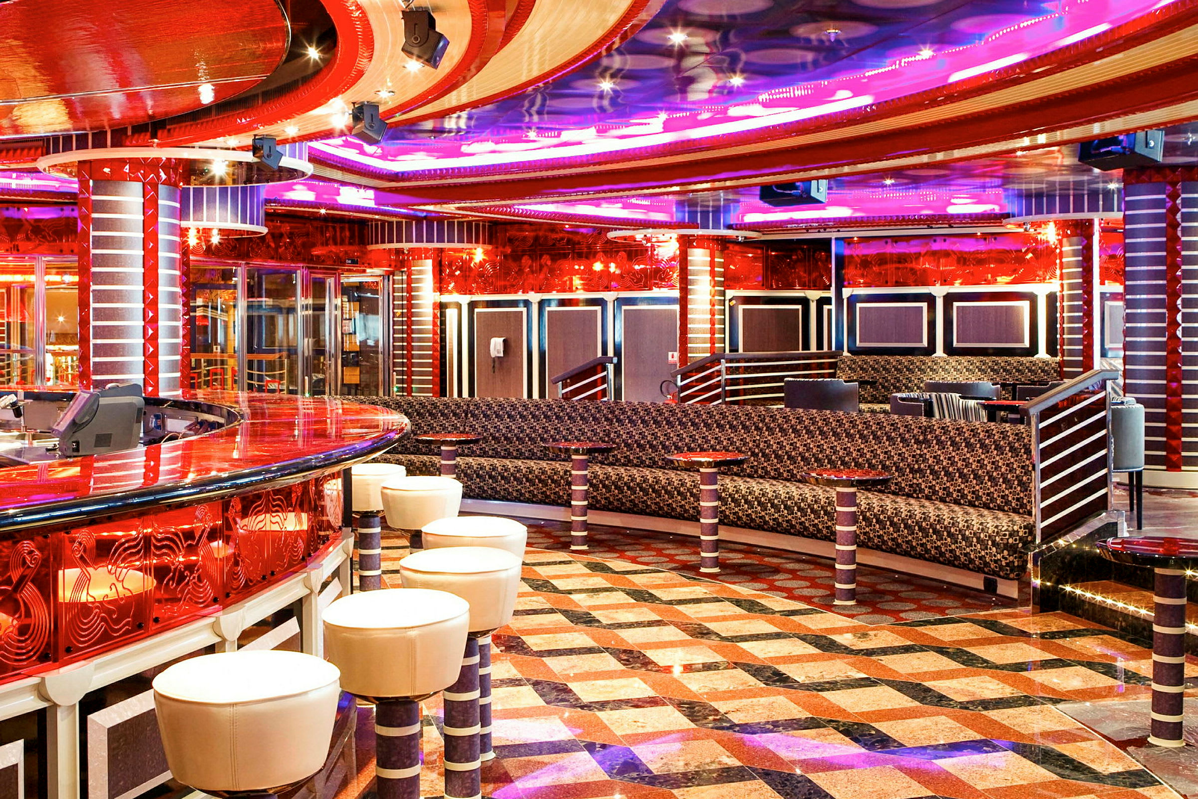 Interiör av en färgglad lounge med bar, sittplatser och mönstrat golv. (AI-genererad text)