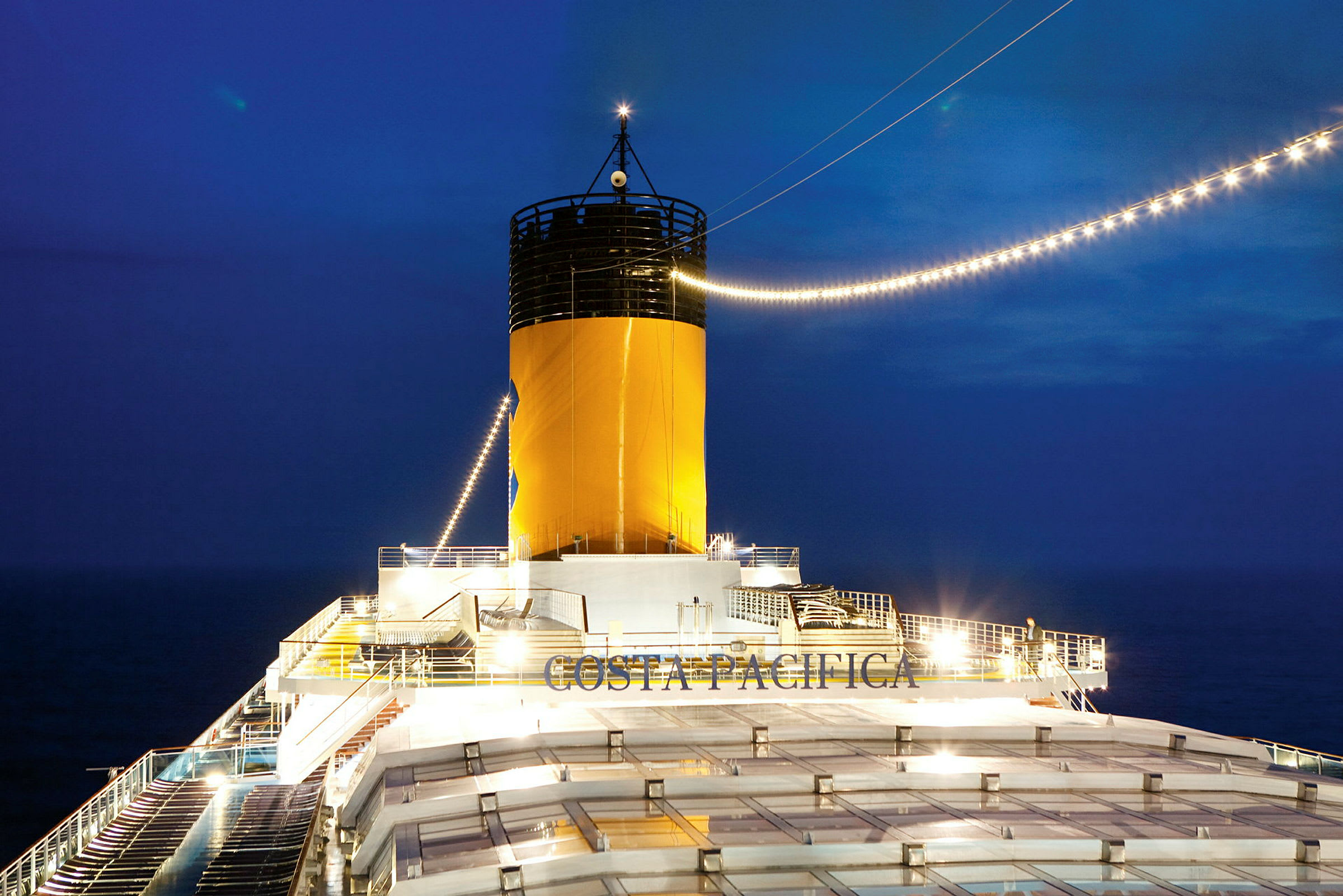 Bild av en kryssningsfartygs skorsten med texten 'Costa Pacifica' synlig vid nattid. (AI-genererad text)