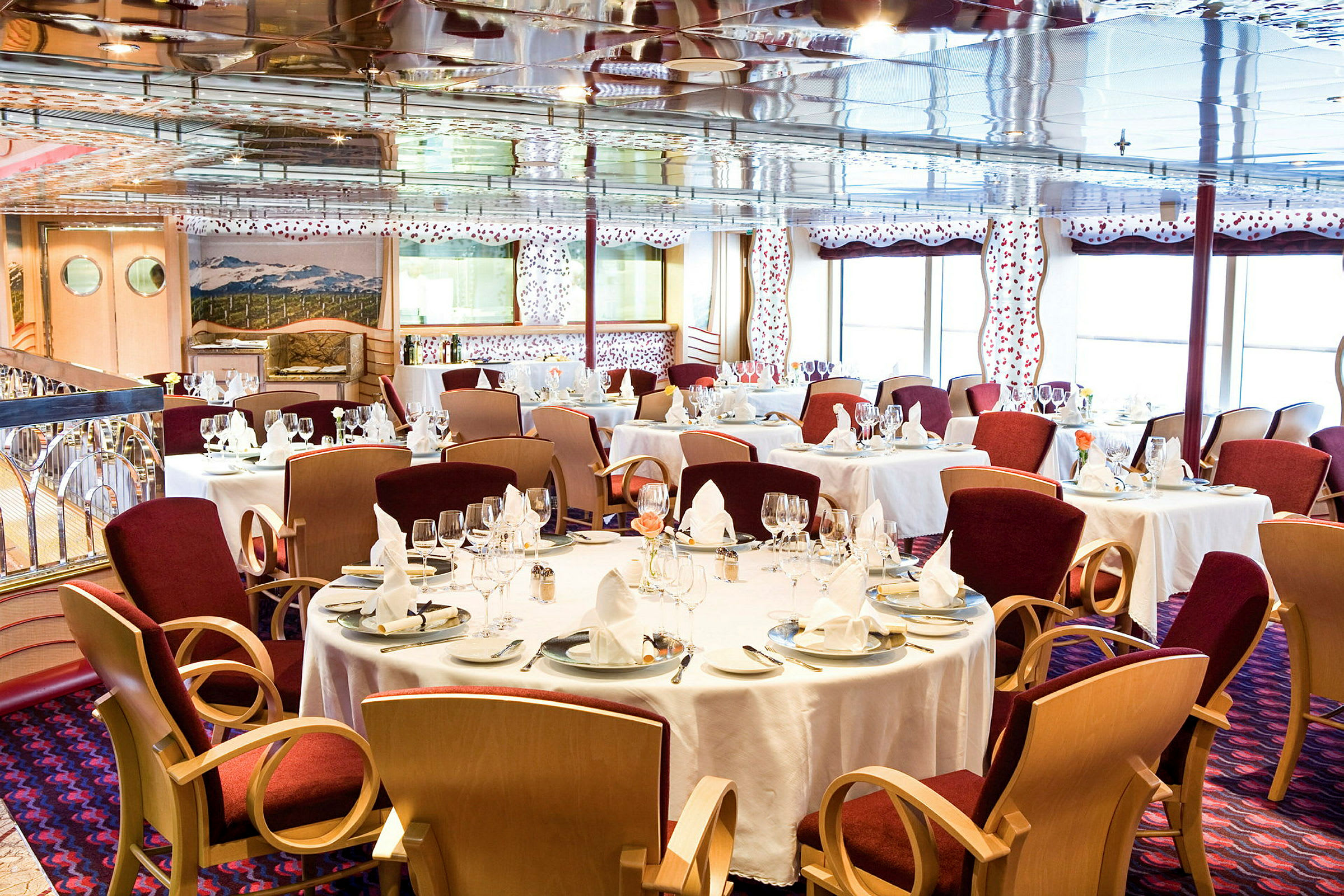En elegant restaurang med dukade bord och röda stolar. (AI-genererad text)