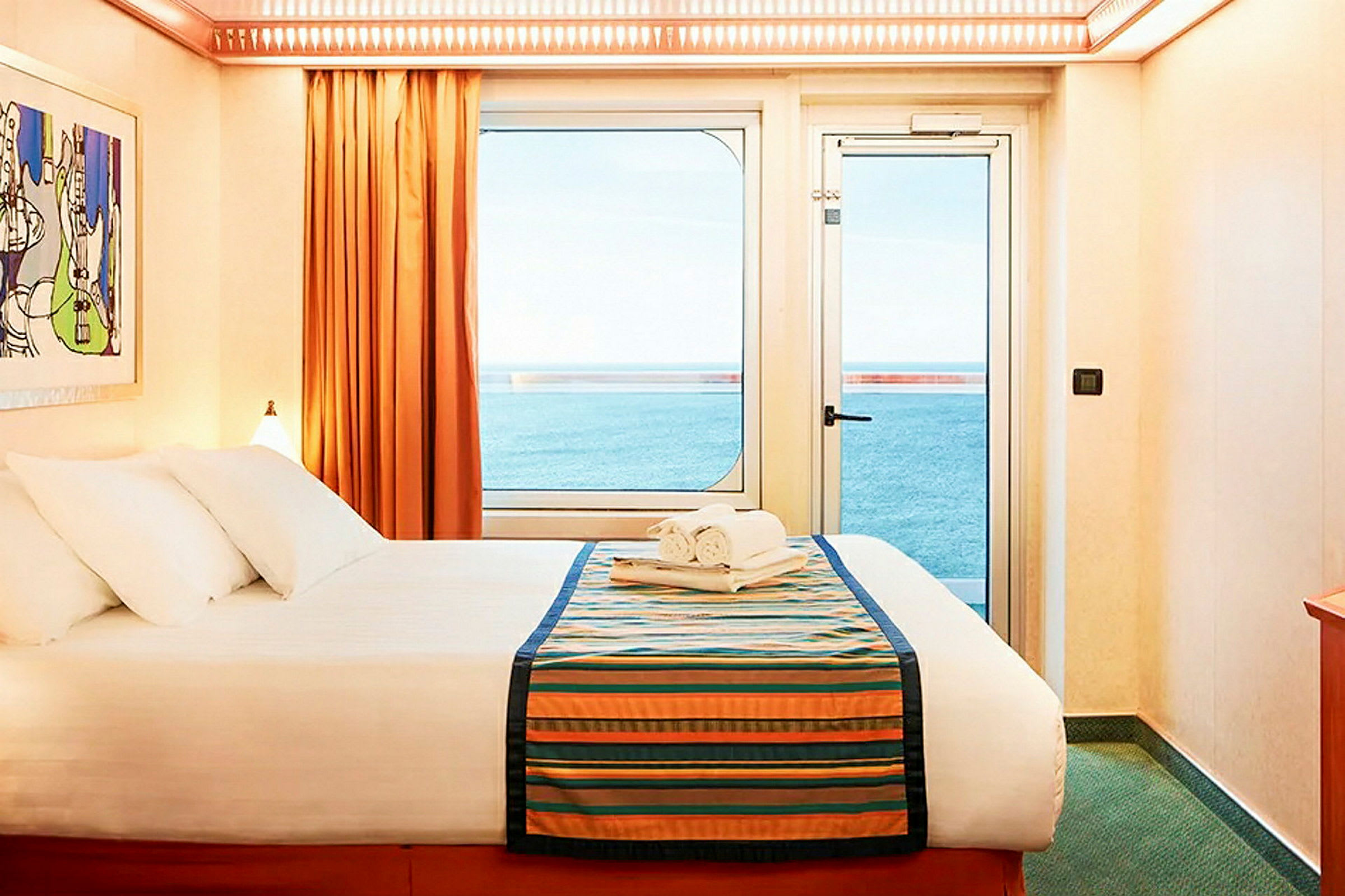 Inomhusbild av ett ljust hotellrum med en dubbelsäng, fönster och utsikt över havet. (AI-genererad text)