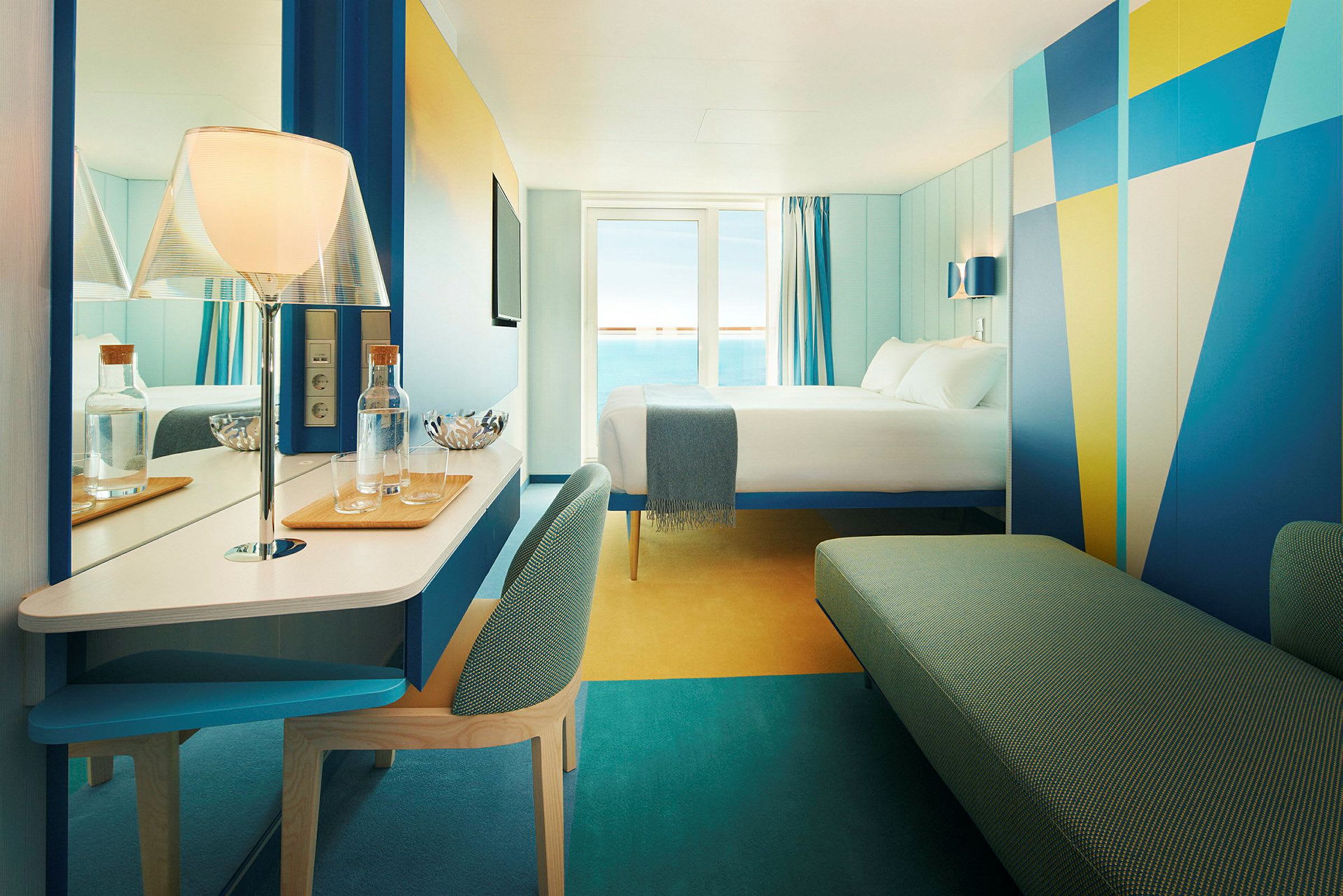 Hotellrum med modern design och havsutsikt. En säng är placerad mot ett fönster med blå gardiner. (AI-genererad text)