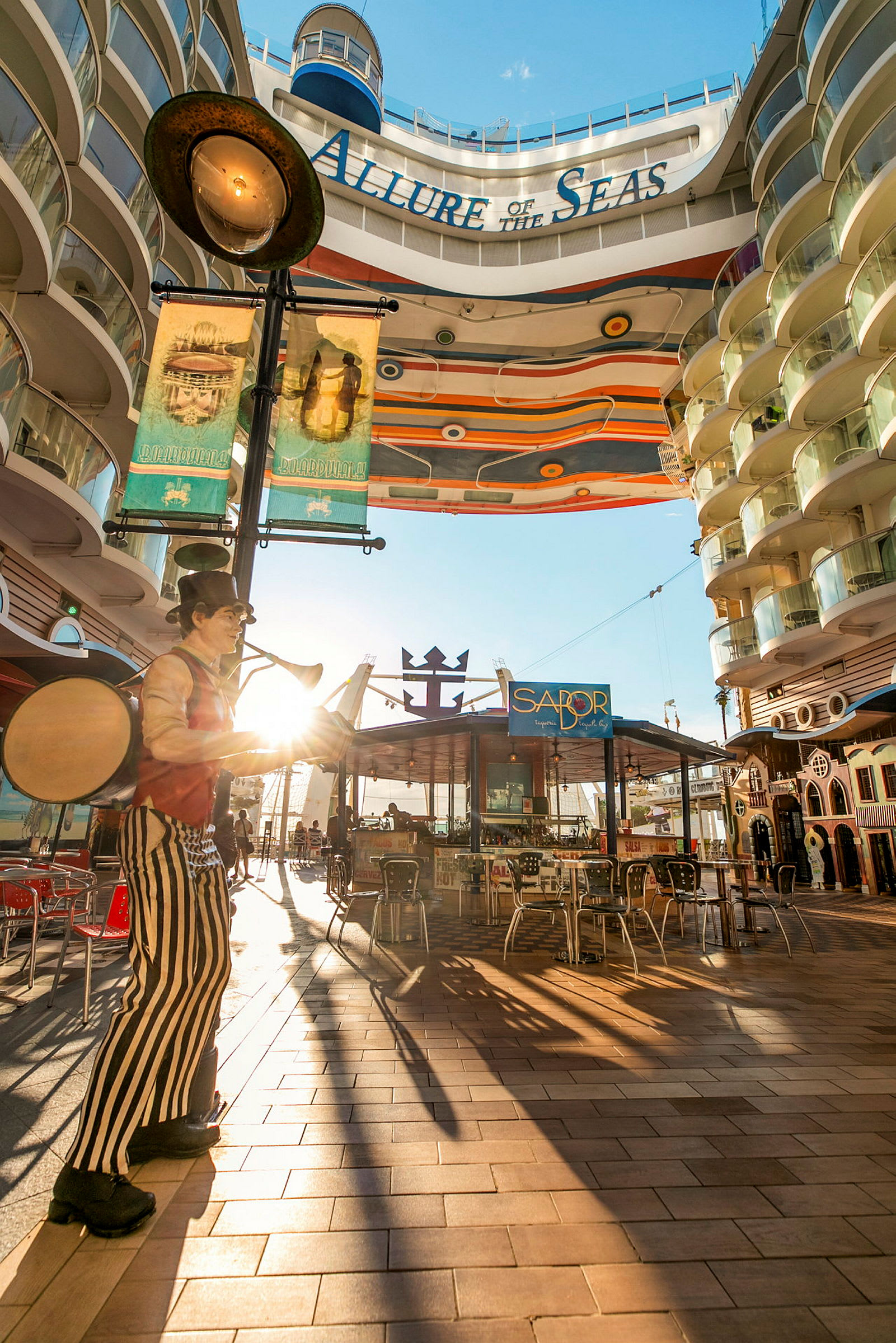 Bild av en solig plats ombord på kryssningsfartyget Allure of the Seas, med en dekorativ gång och restauranger. (AI-genererad text)