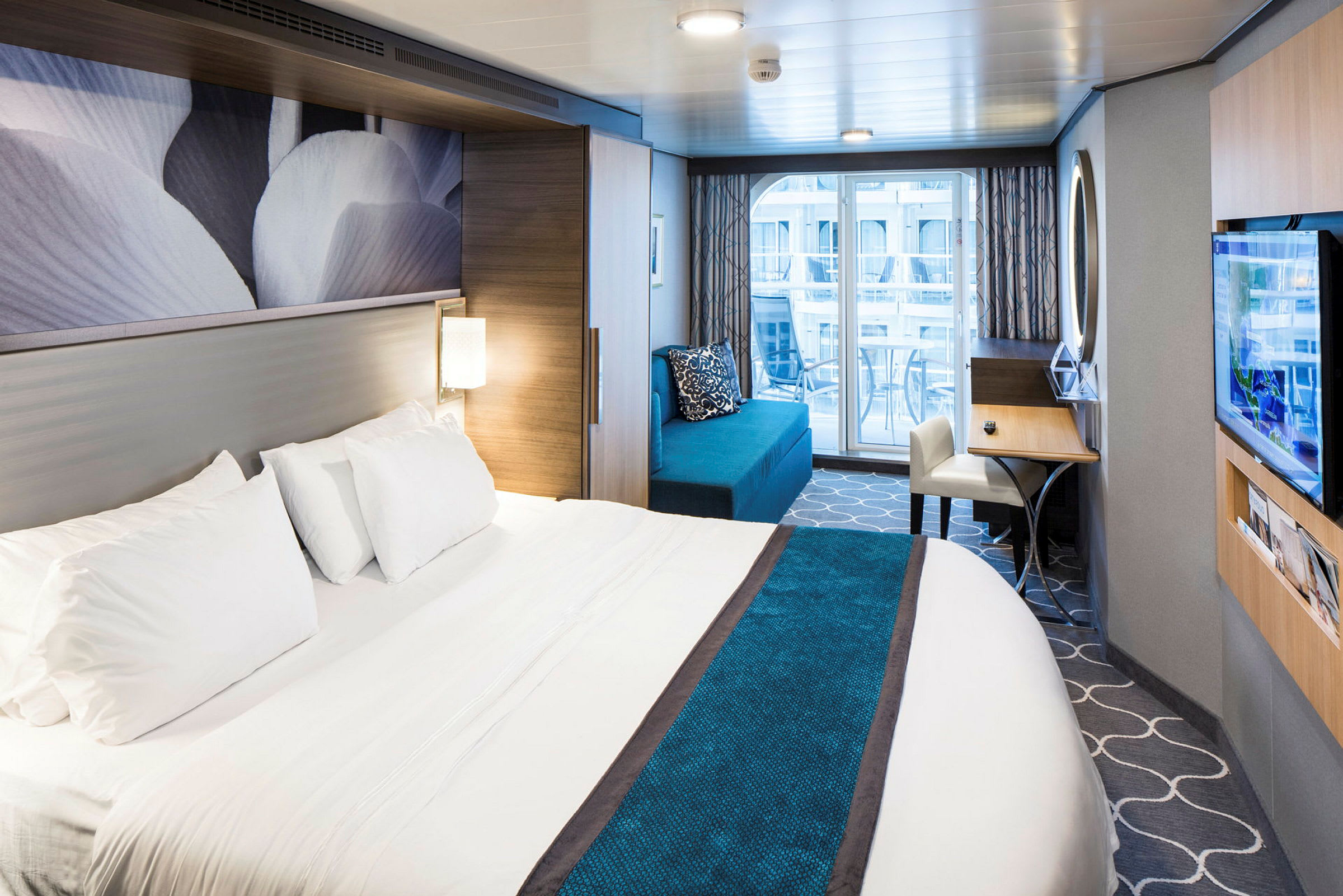 Hotellrum med en stor säng, soffa, skrivbord och balkong. (AI-genererad text)