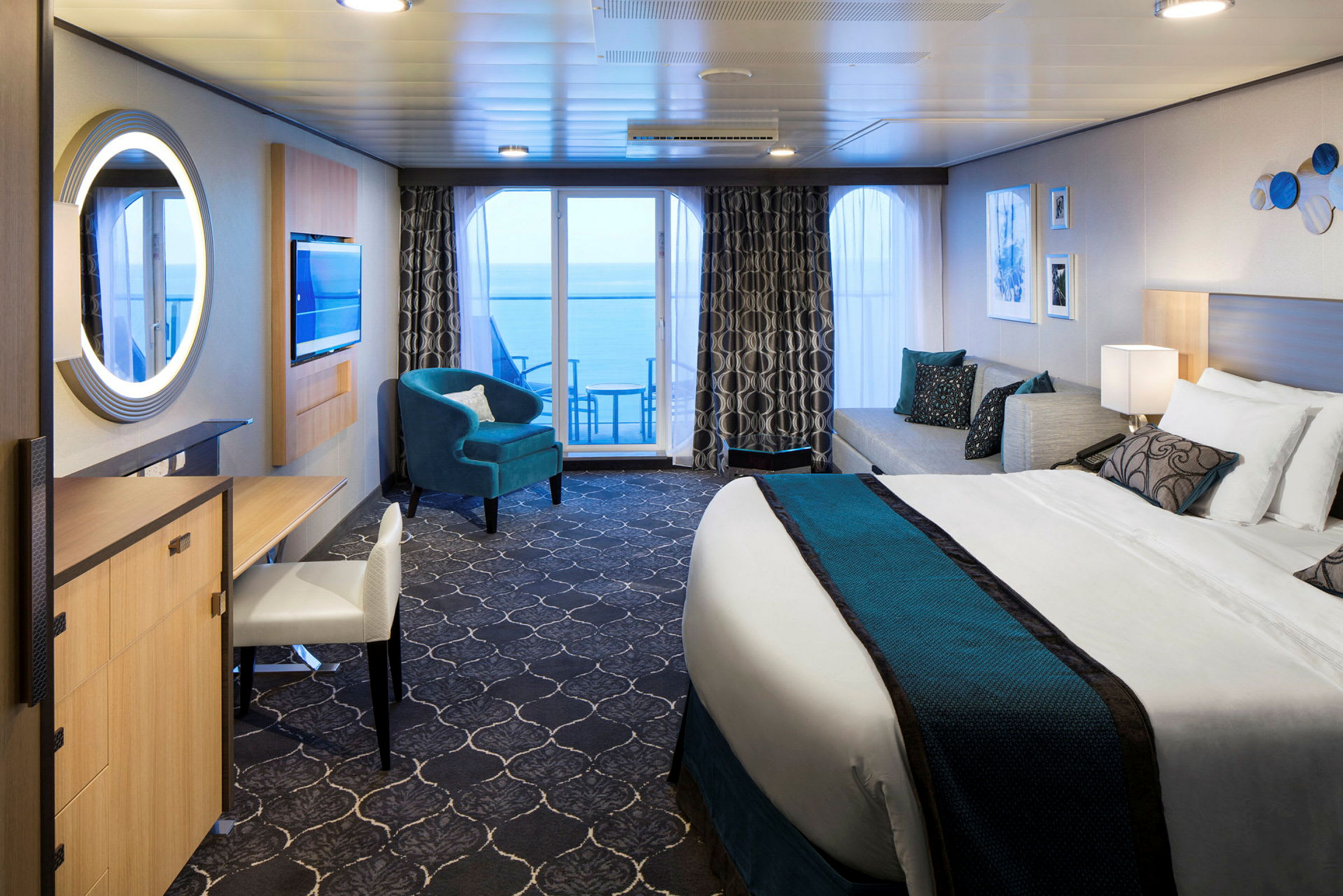 Ett modernt hotellrum med stor säng, sittmöbler och balkong med havsutsikt. (AI-genererad text)