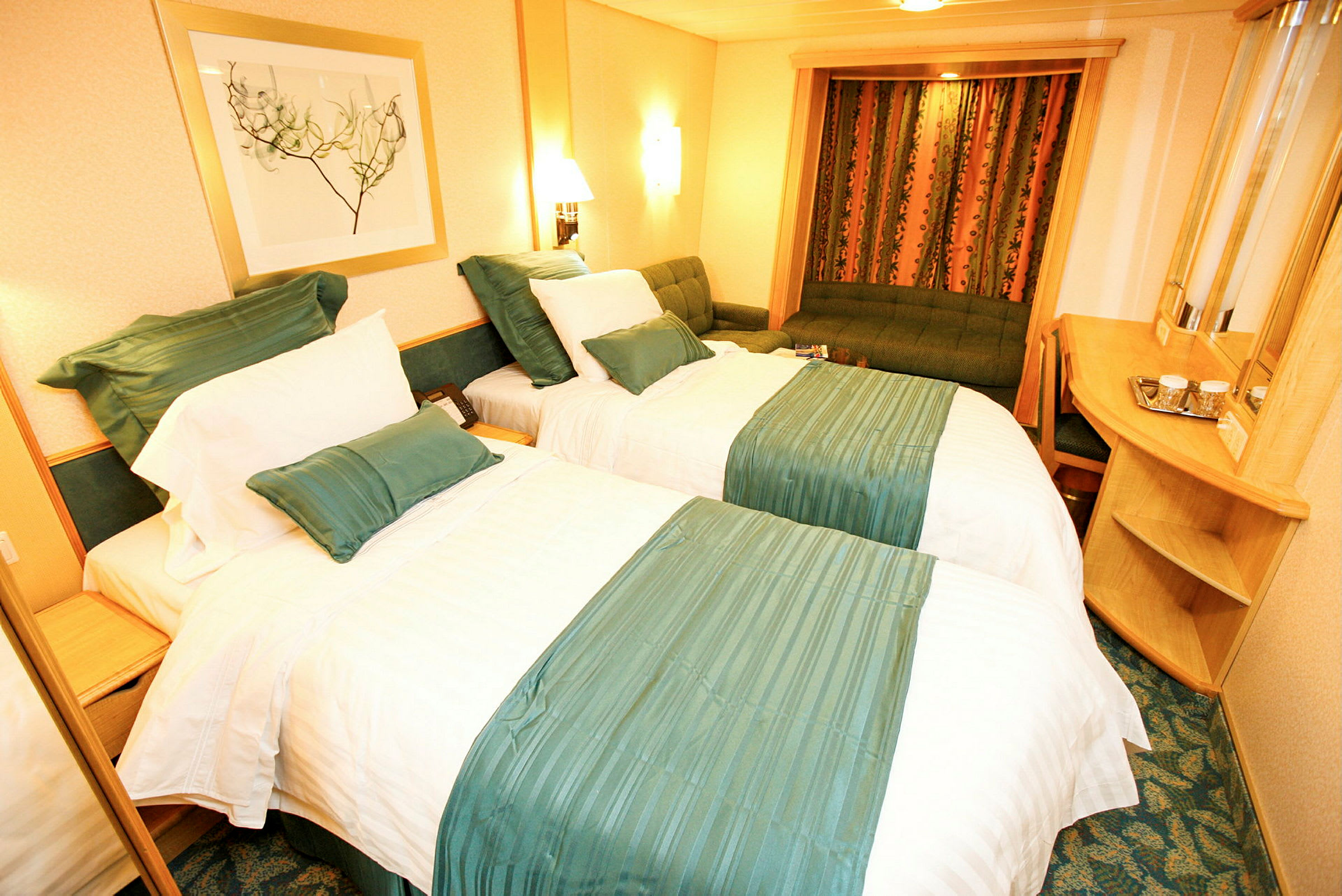 Hotellrum med två sängar klädda i vita och gröna sängkläder, en soffa och ett skrivbord. (AI-genererad text)