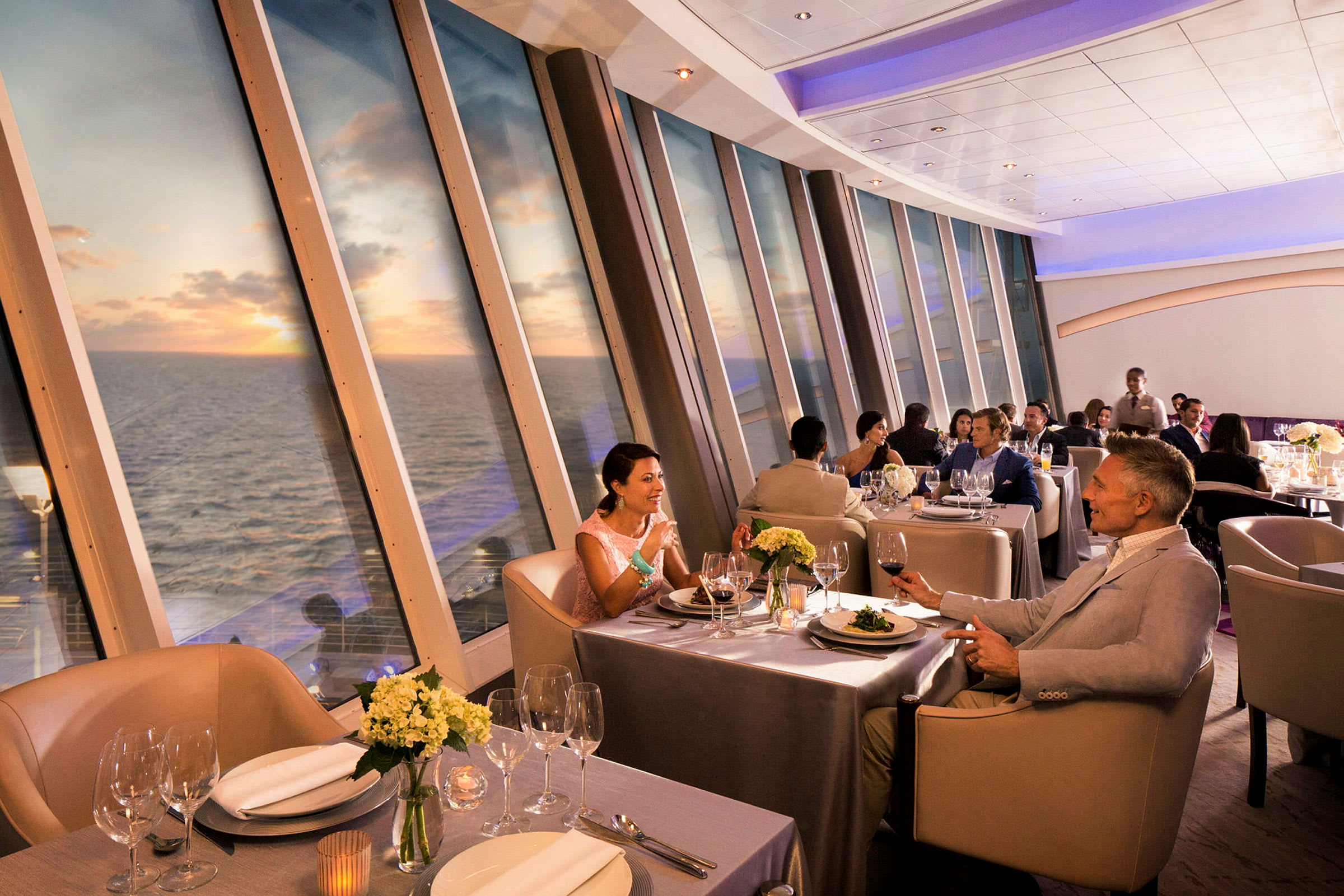 Elegant restaurang med panoramautsikt över havet och solnedgång. (AI-genererad text)