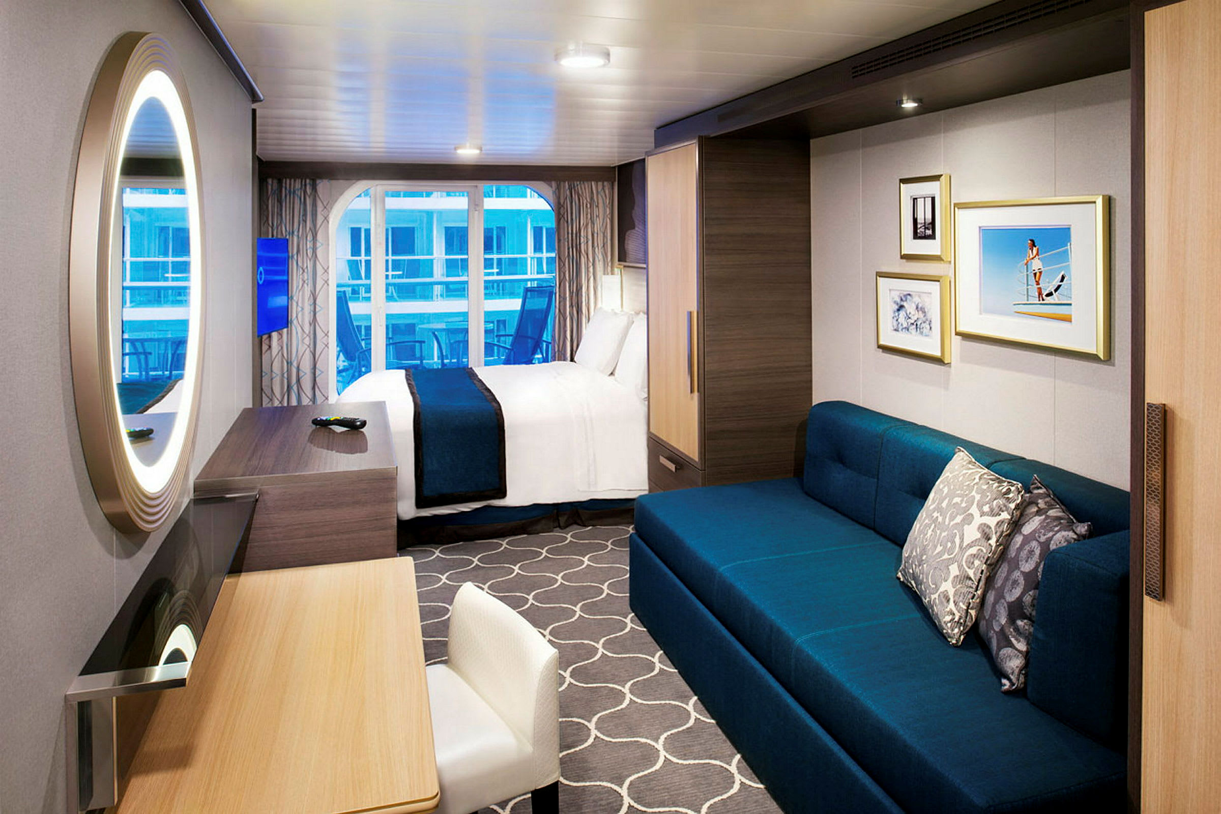Ett modernt hotellrum med en stor spegel, skrivbord, soffa och en säng, samt ett fönster med utsikt. (AI-genererad text)