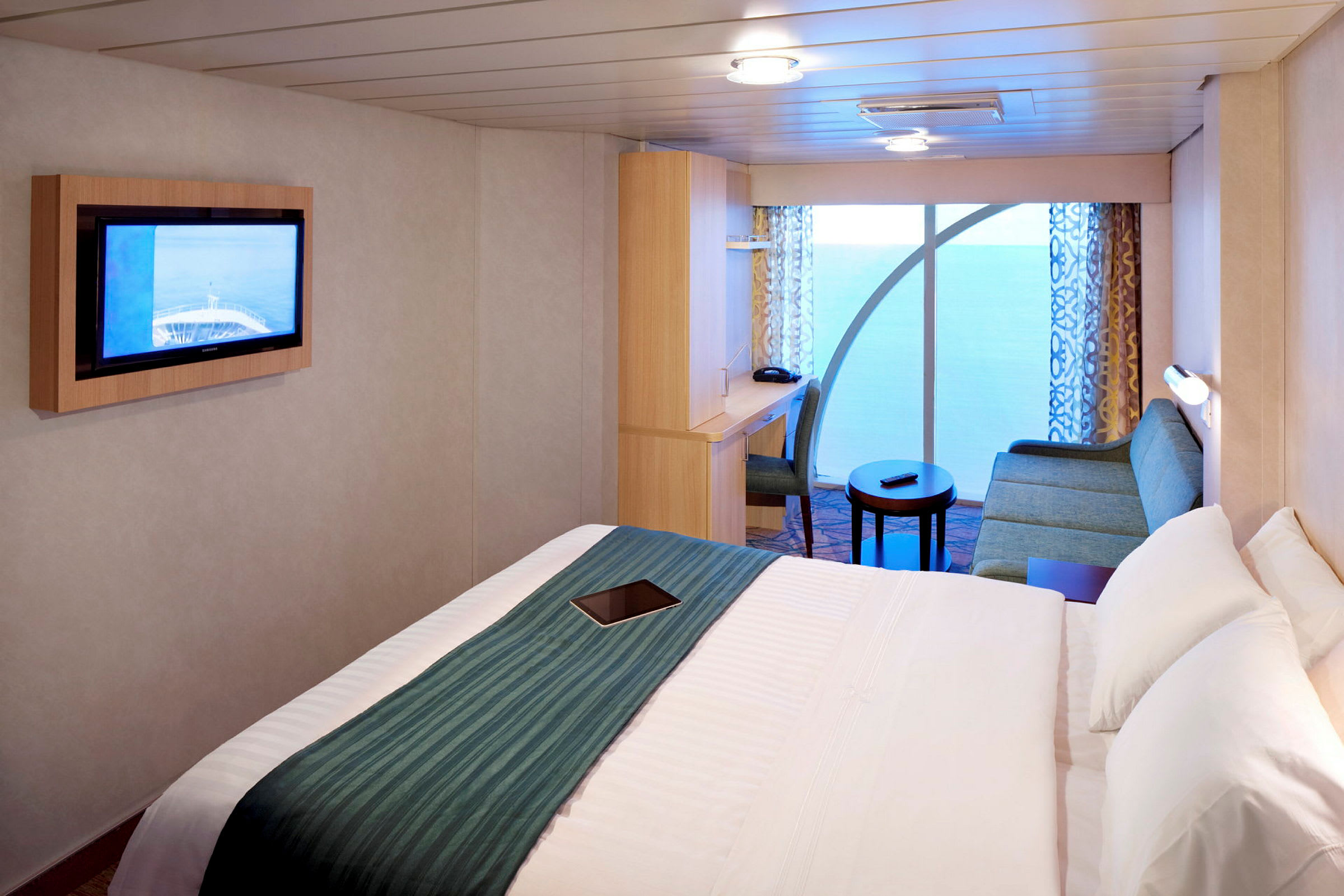 Ett hotellrum med säng, soffa, tv och skrivbord. (AI-genererad text)