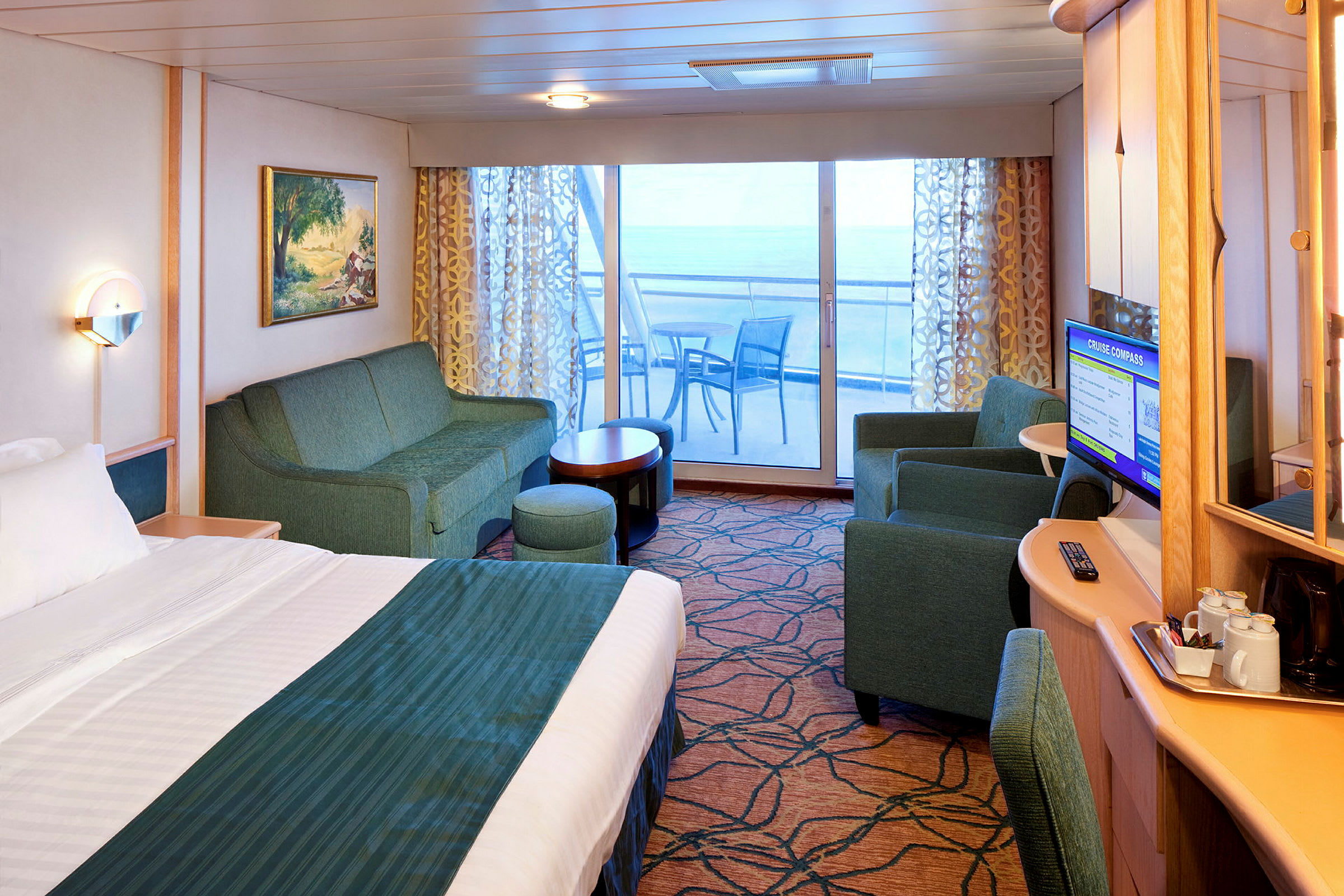 Ett hotellrum med säng, soffa, bord, TV och en balkong med utsikt. (AI-genererad text)