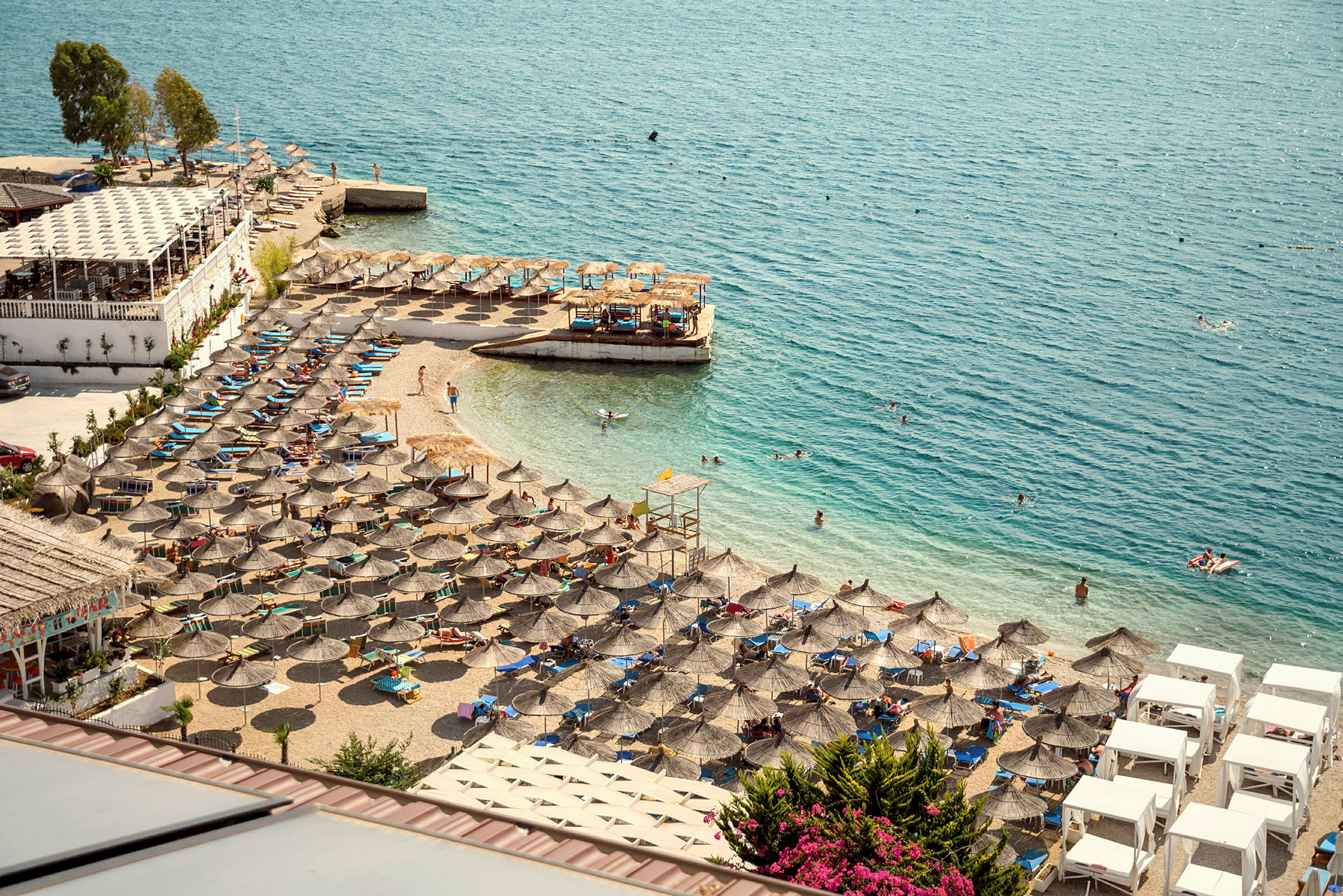Solstolar och parasoller på en strand vid vattnet. (AI-genererad text)