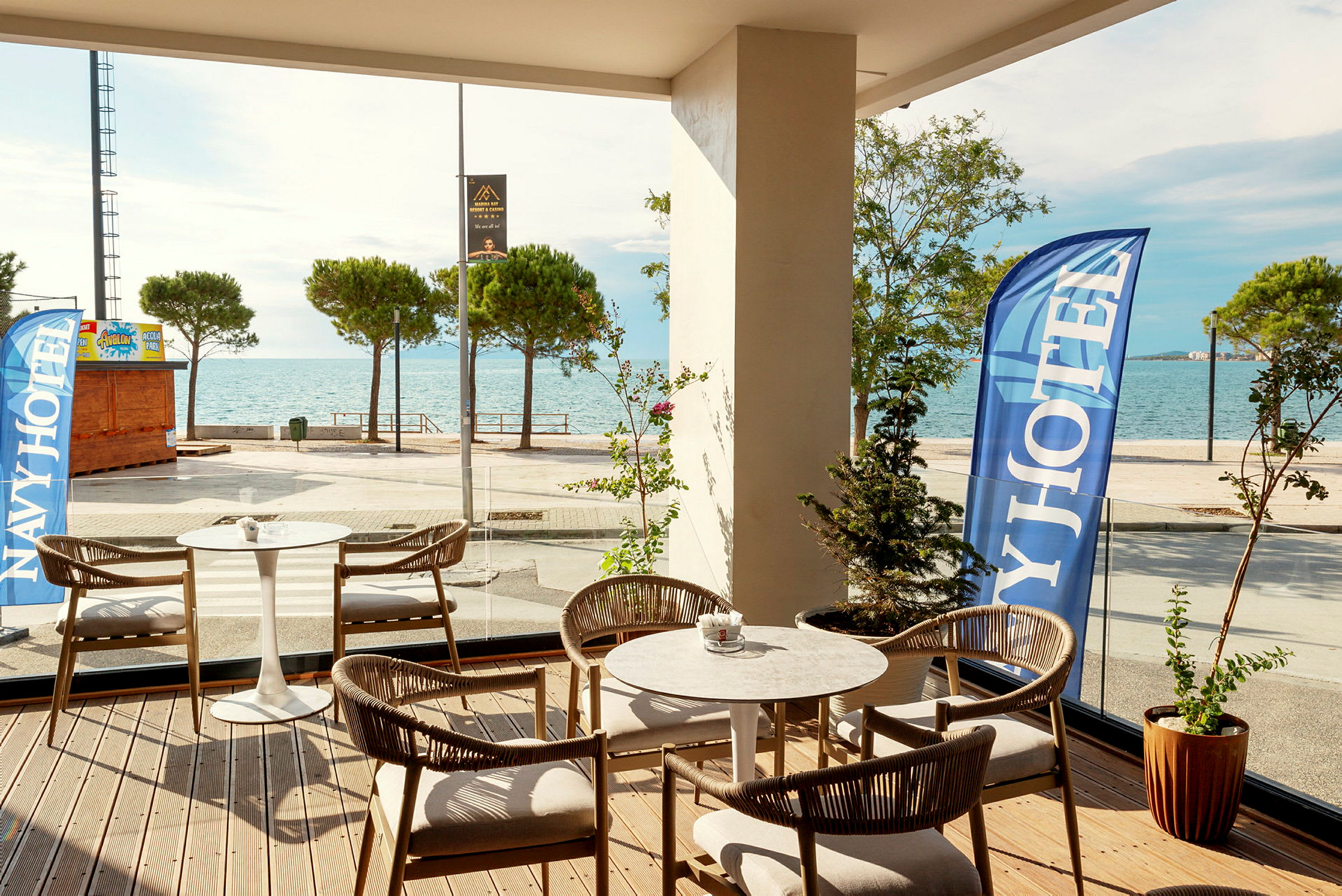 Hotellets terrass med havsutsikt och bekväma sittplatser. (AI-genererad text)