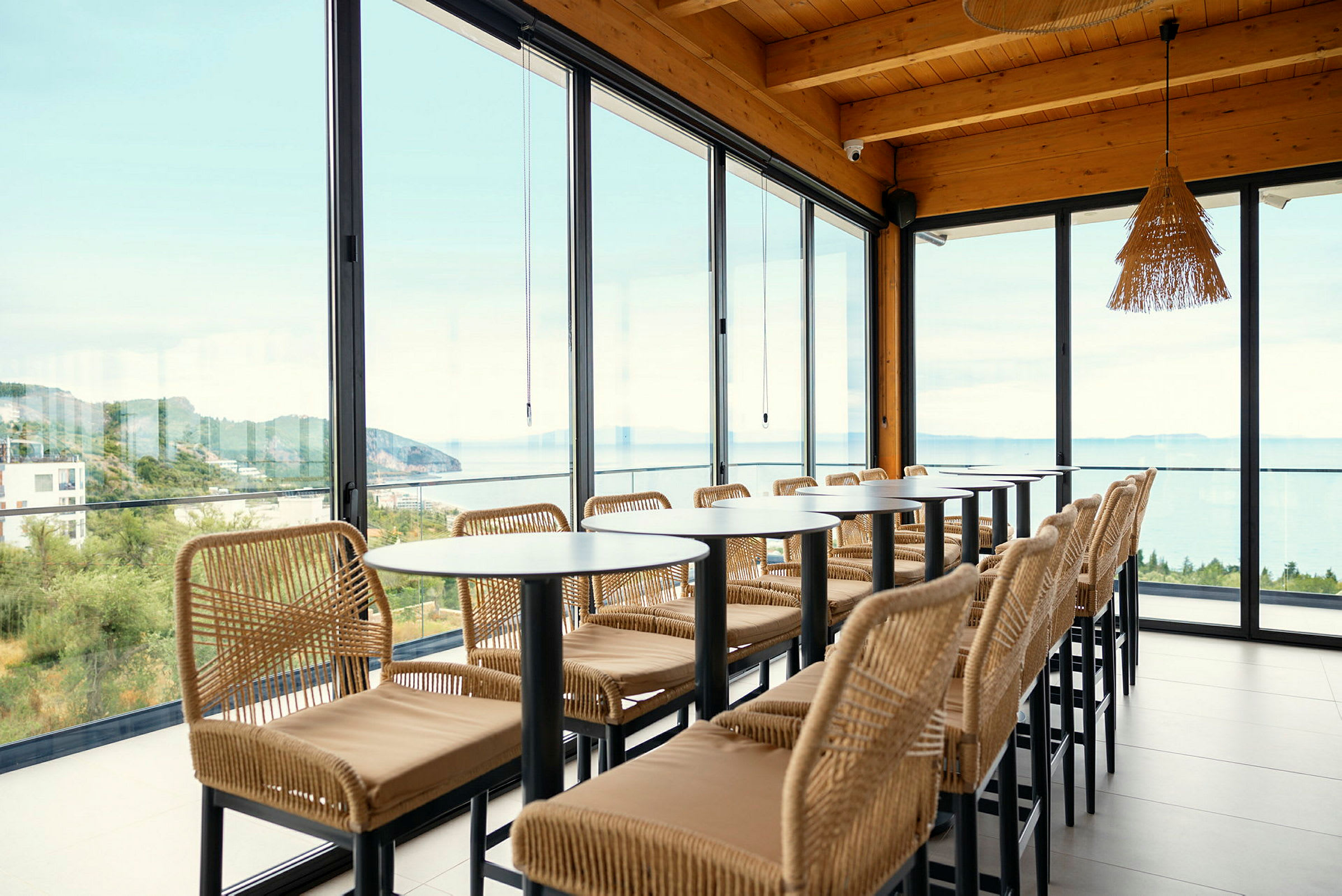 Restaurang med stora glasfönster och utsikt över havet. (AI-genererad text)