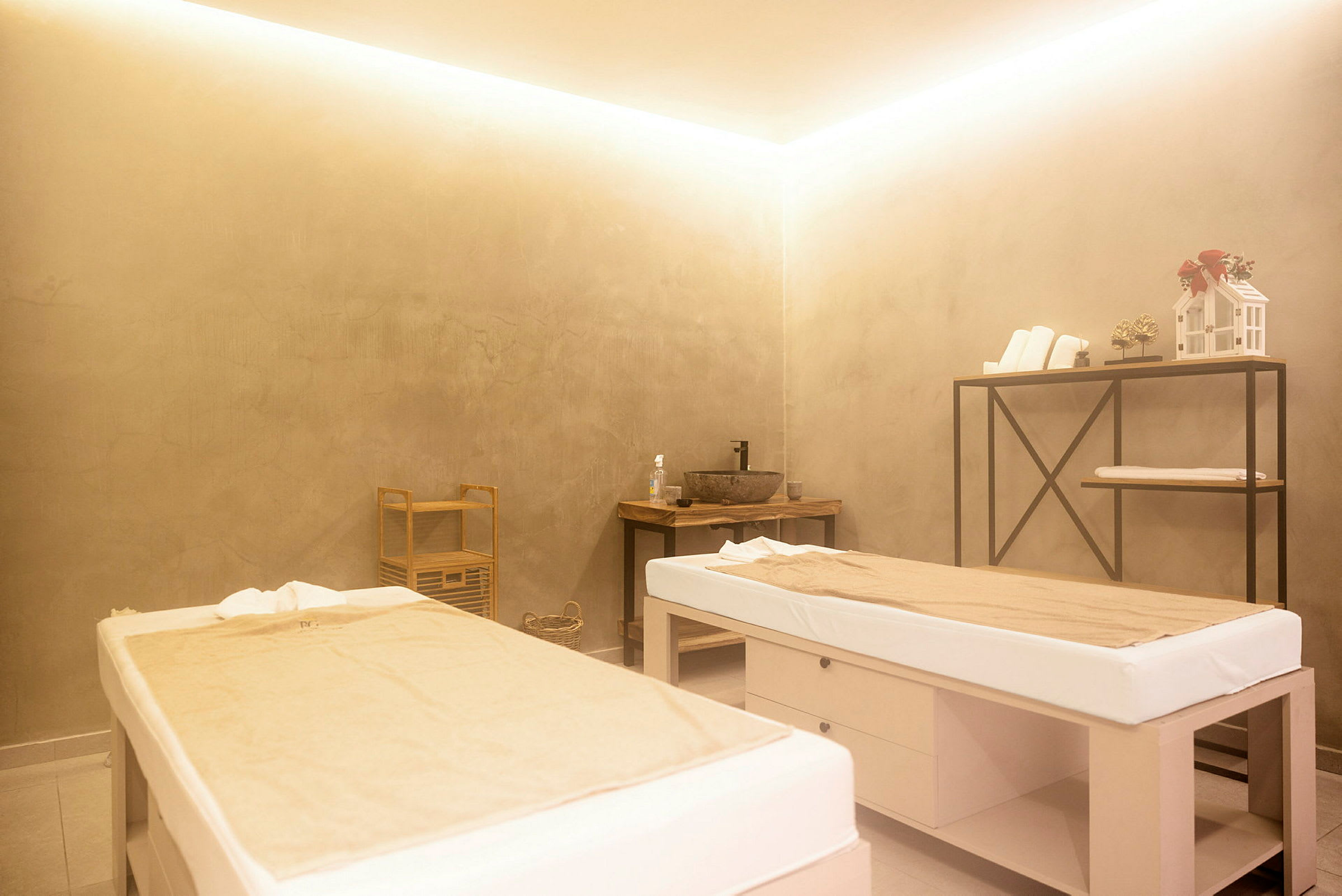 Två massagebänkar i ett spa-rum med diskret inredning. (AI-genererad text)