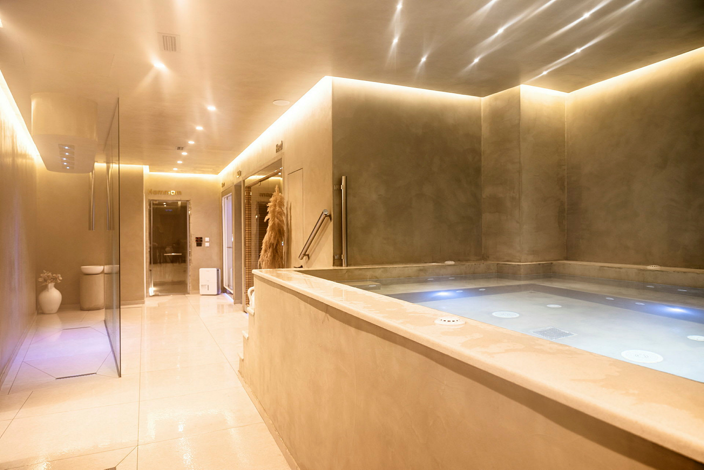 En avslappnad inomhusmiljö med en jacuzzi och ljussättning. (AI-genererad text)