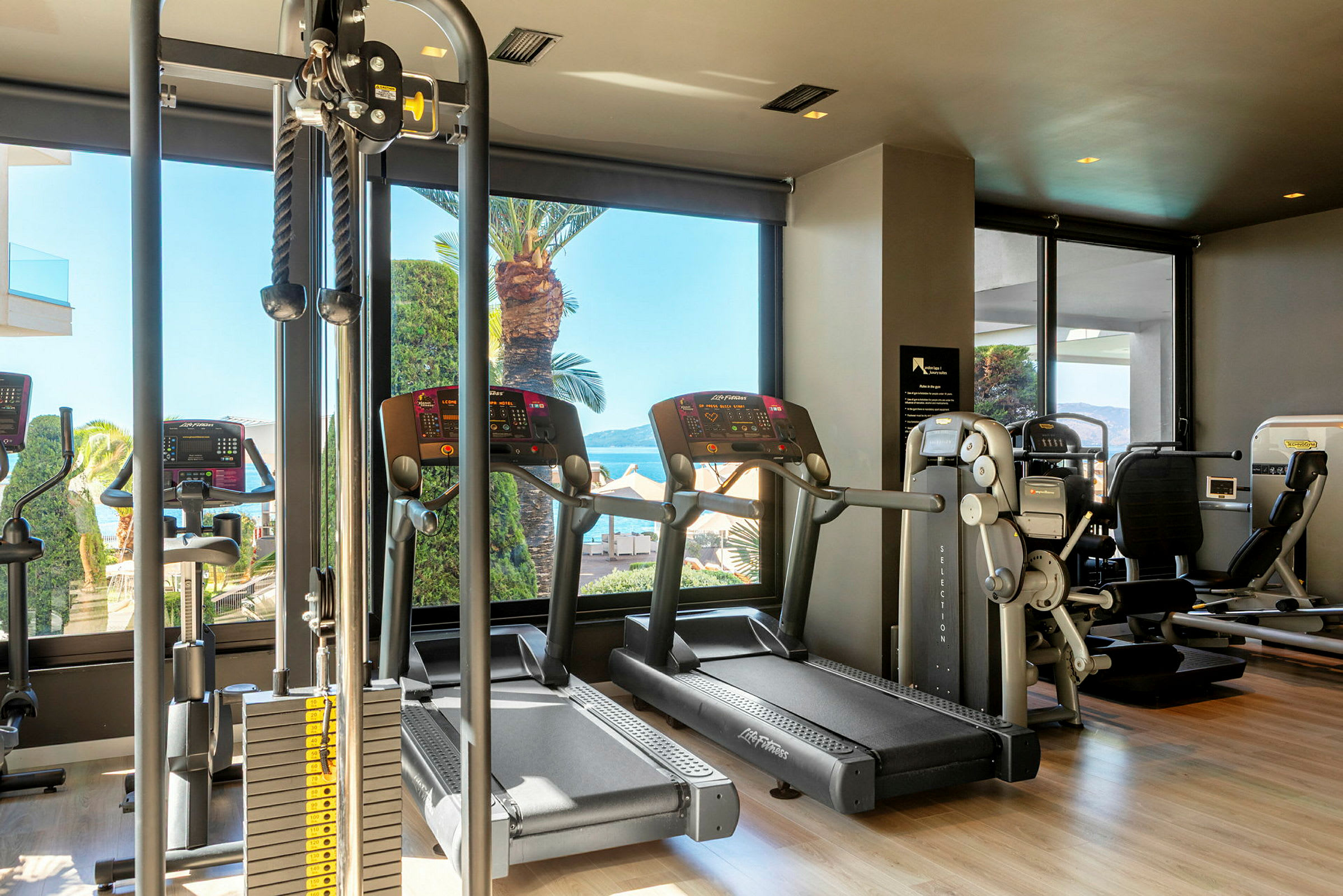 Bild på ett gym med olika träningsmaskiner, inklusive löpband och styrketräningsutrustning. (AI-genererad text)