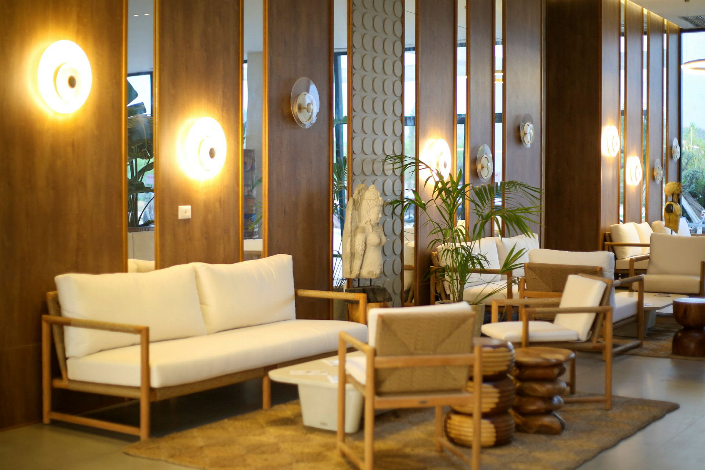 En elegant lounge med vita sittmöbler och träpaneler på väggen. (AI-genererad text)