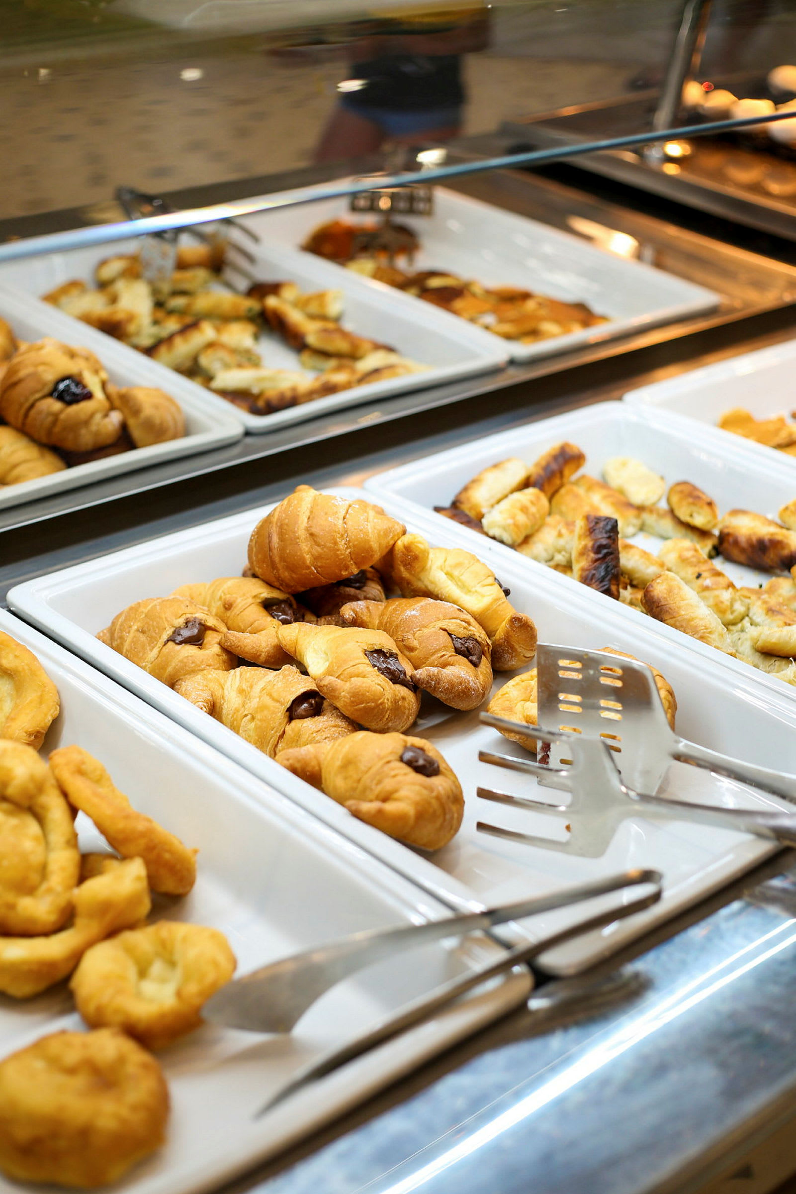 Display med bakverk i olika serveringsfat, inklusive croissanter. (AI-genererad text)