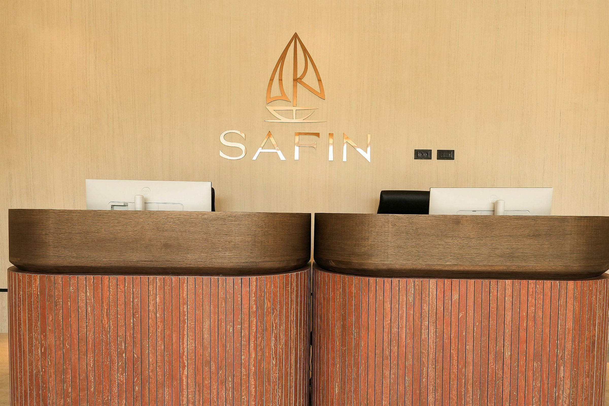Två receptionsdiskar av trä med moderna kontorsskärmar på, mot en ljus bakgrund med texten 'SAFIN'. (AI-genererad text)