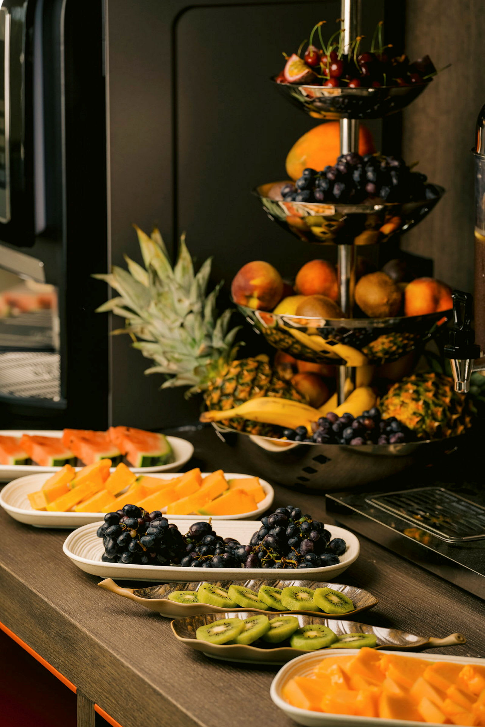 En bufféuppsättning med olika färska frukter som druvor, kiwi, vattenmelon och ananas. (AI-genererad text)