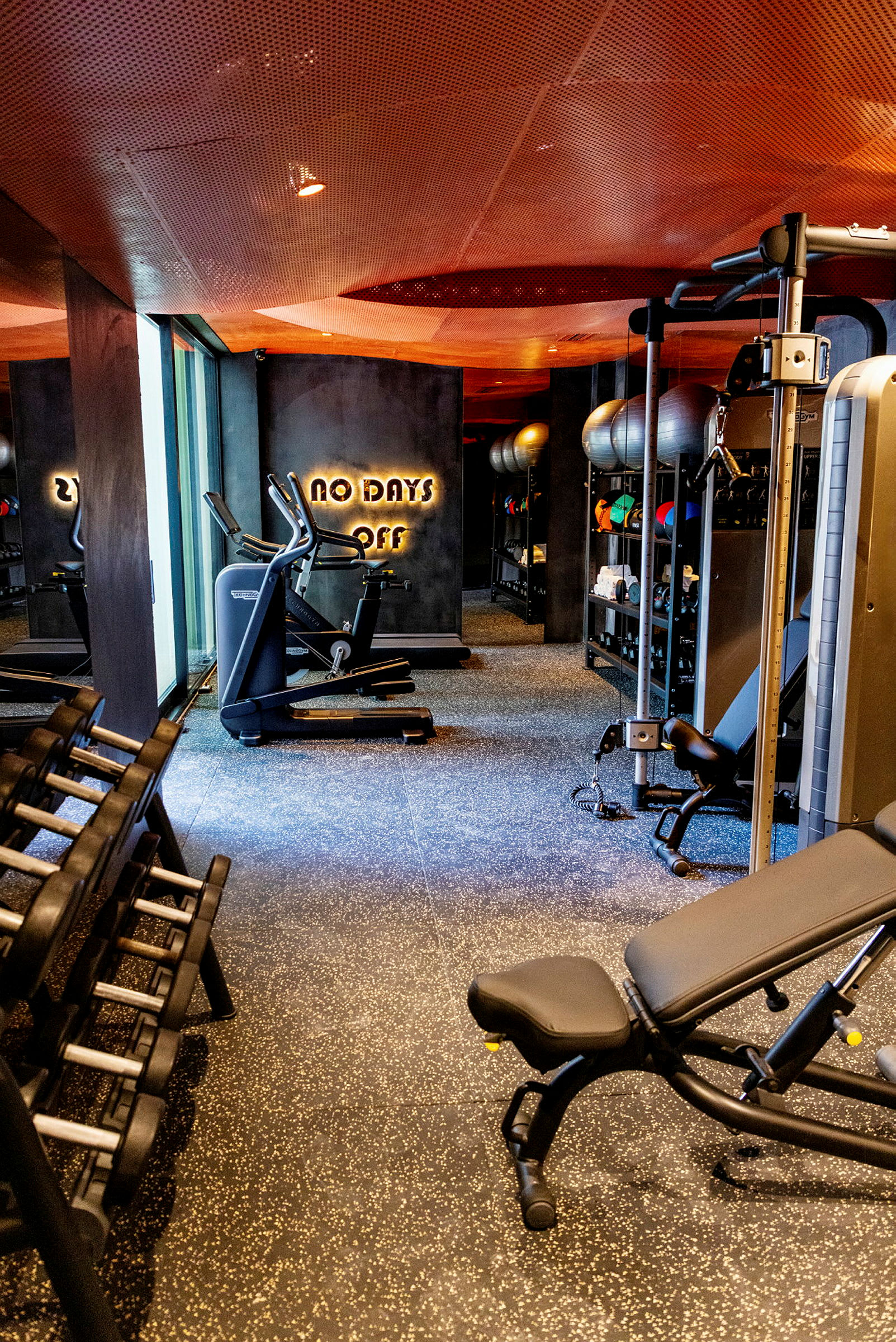 Ett modernt gym med träningsutrustning som hantlar, maskiner och motionscyklar. (AI-genererad text)
