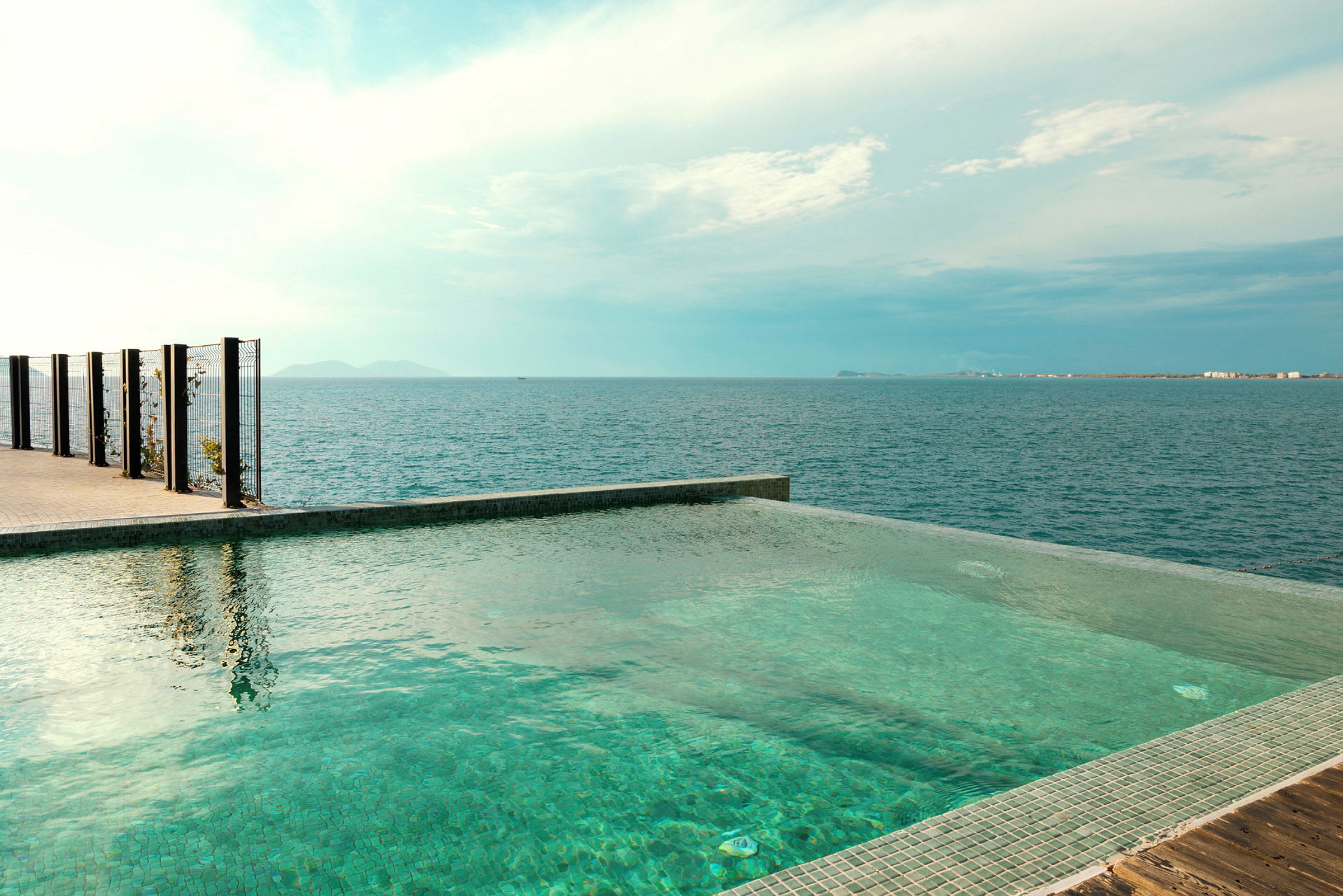 En infinitypool med utsikt över havet och en klar himmel. (AI-genererad text)