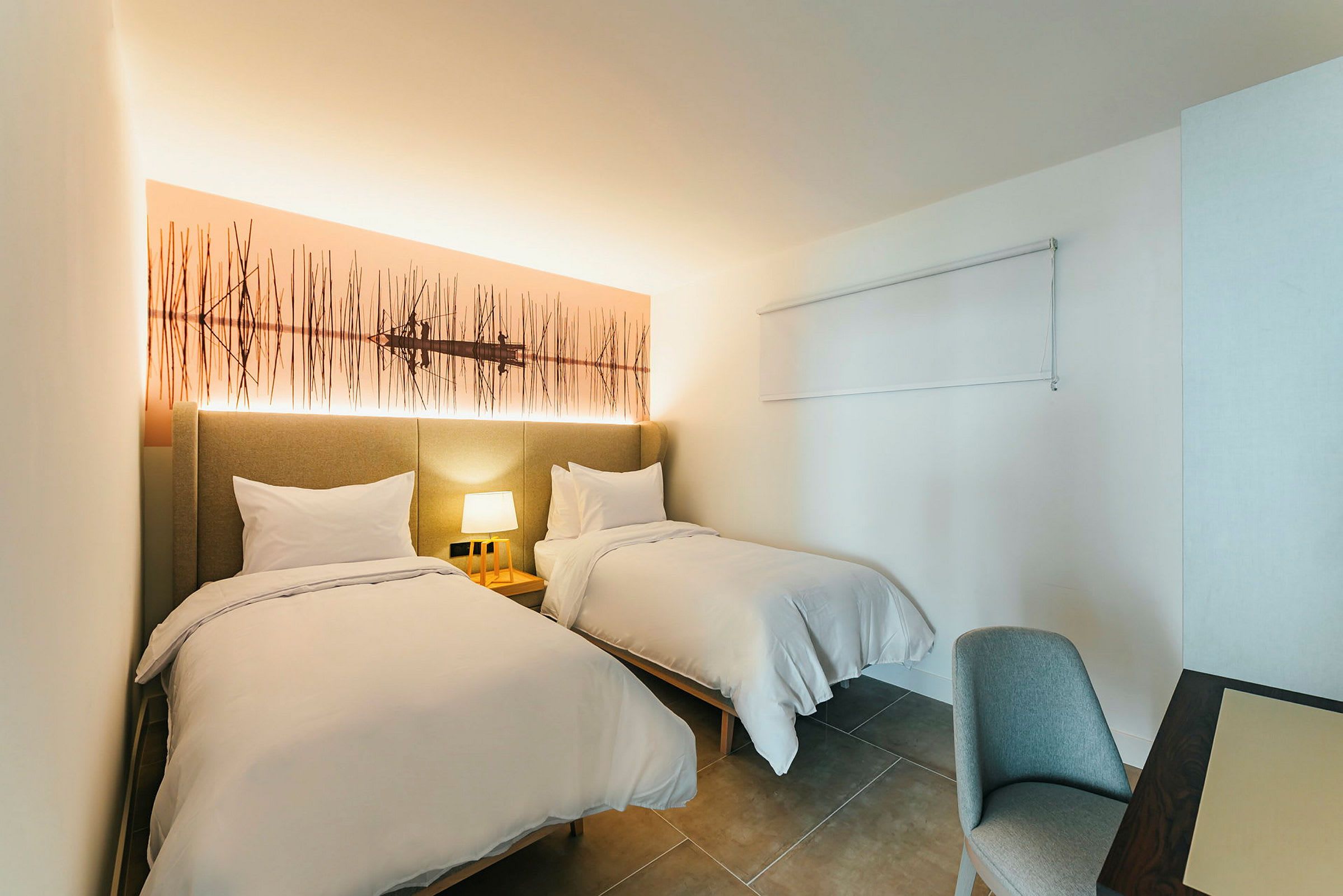 Ett hotellrum med två enkelsängar och en nattlampa. (AI-genererad text)
