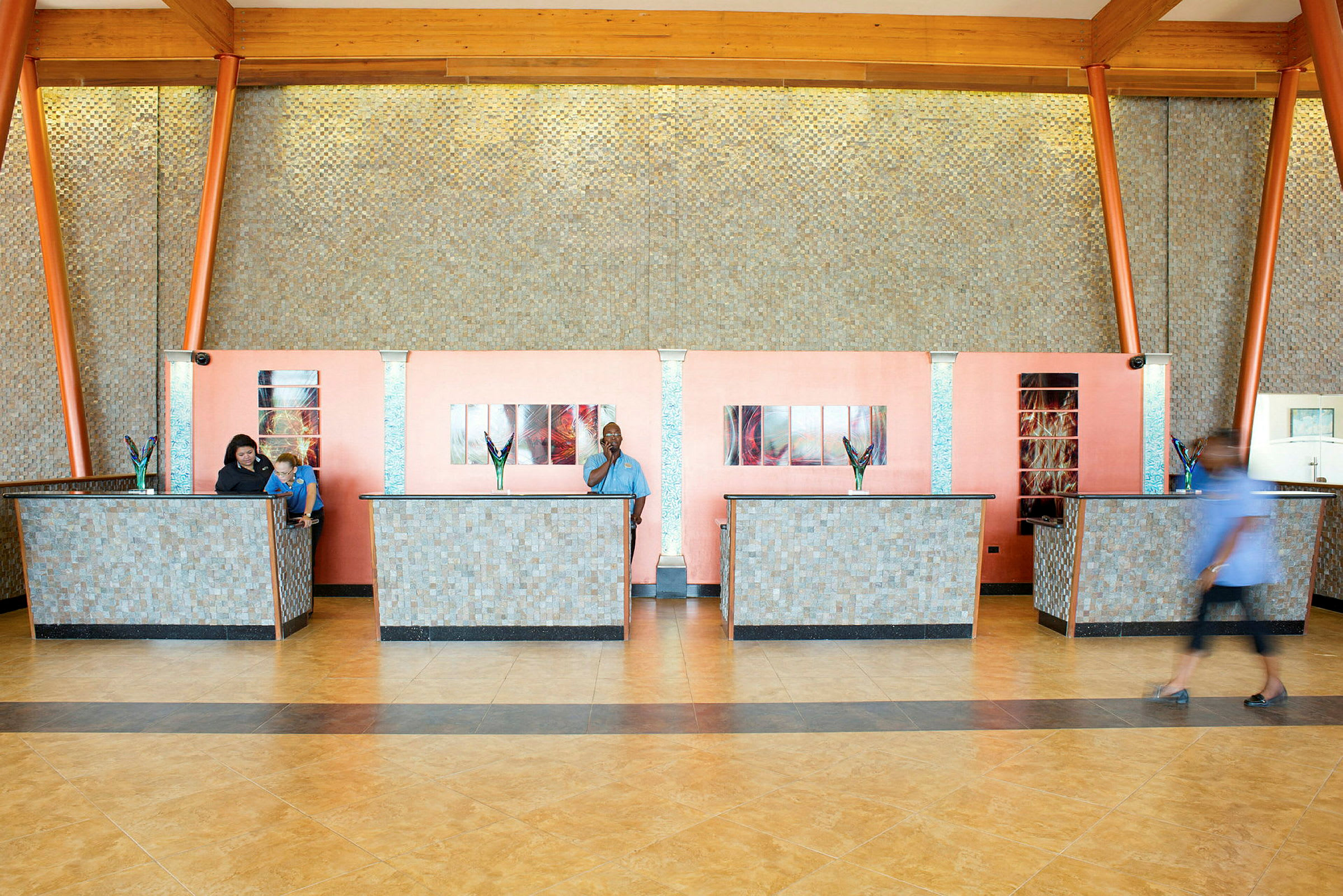 En reception med flera servicediskar och dekorativa blommor. Väggarna har en skiftande mosaikdesign. (AI-genererad text)