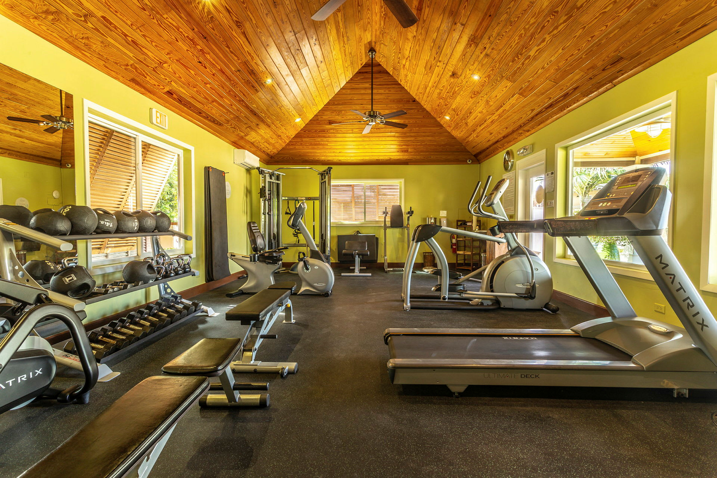 Ett gym med träningsutrustning som löpband, vikter och träningsbänkar. (AI-genererad text)