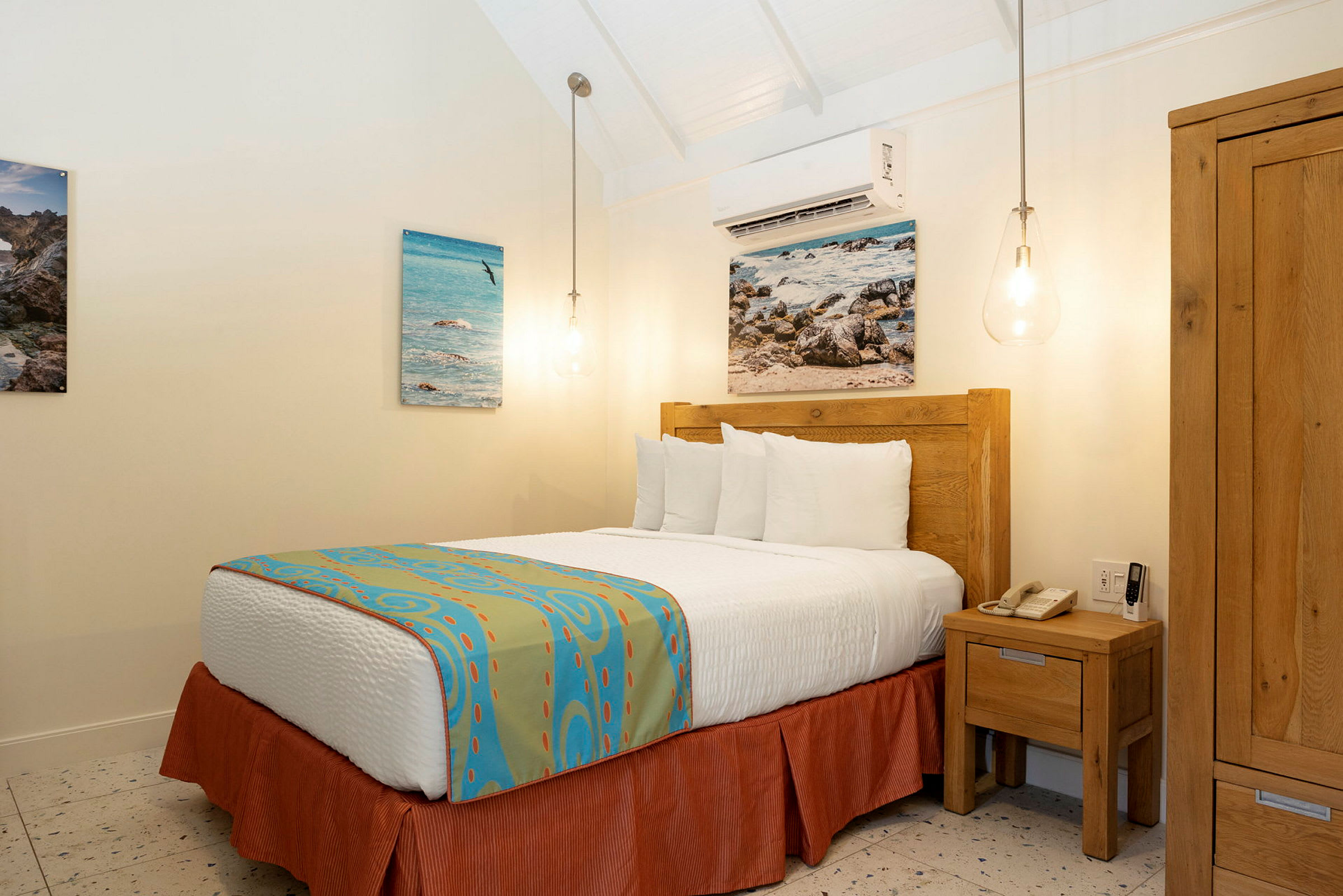 Ett hotellrum med en säng, trämöbler och väggdekorationer. (AI-genererad text)
