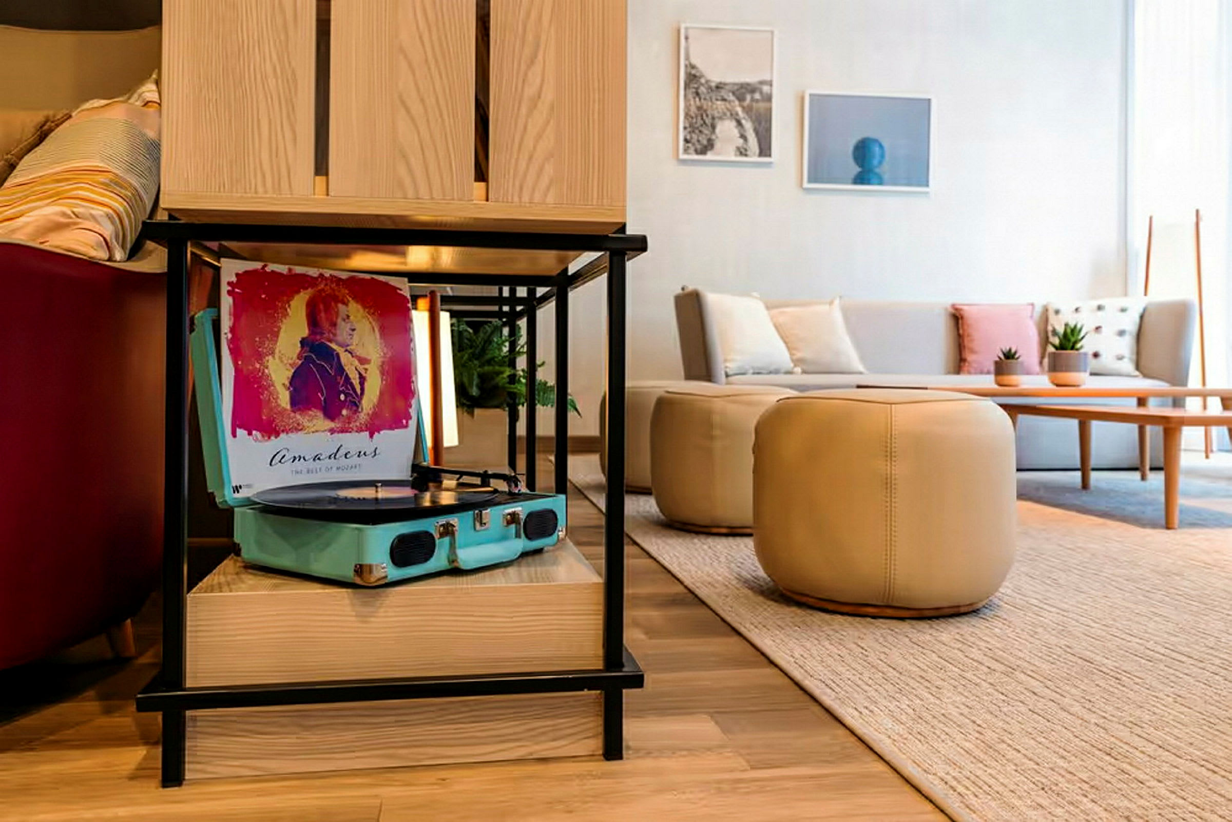 Bild av ett modernt vardagsrum med en skivspelare på en hylla och en soffa med kuddar i bakgrunden. (AI-genererad text)