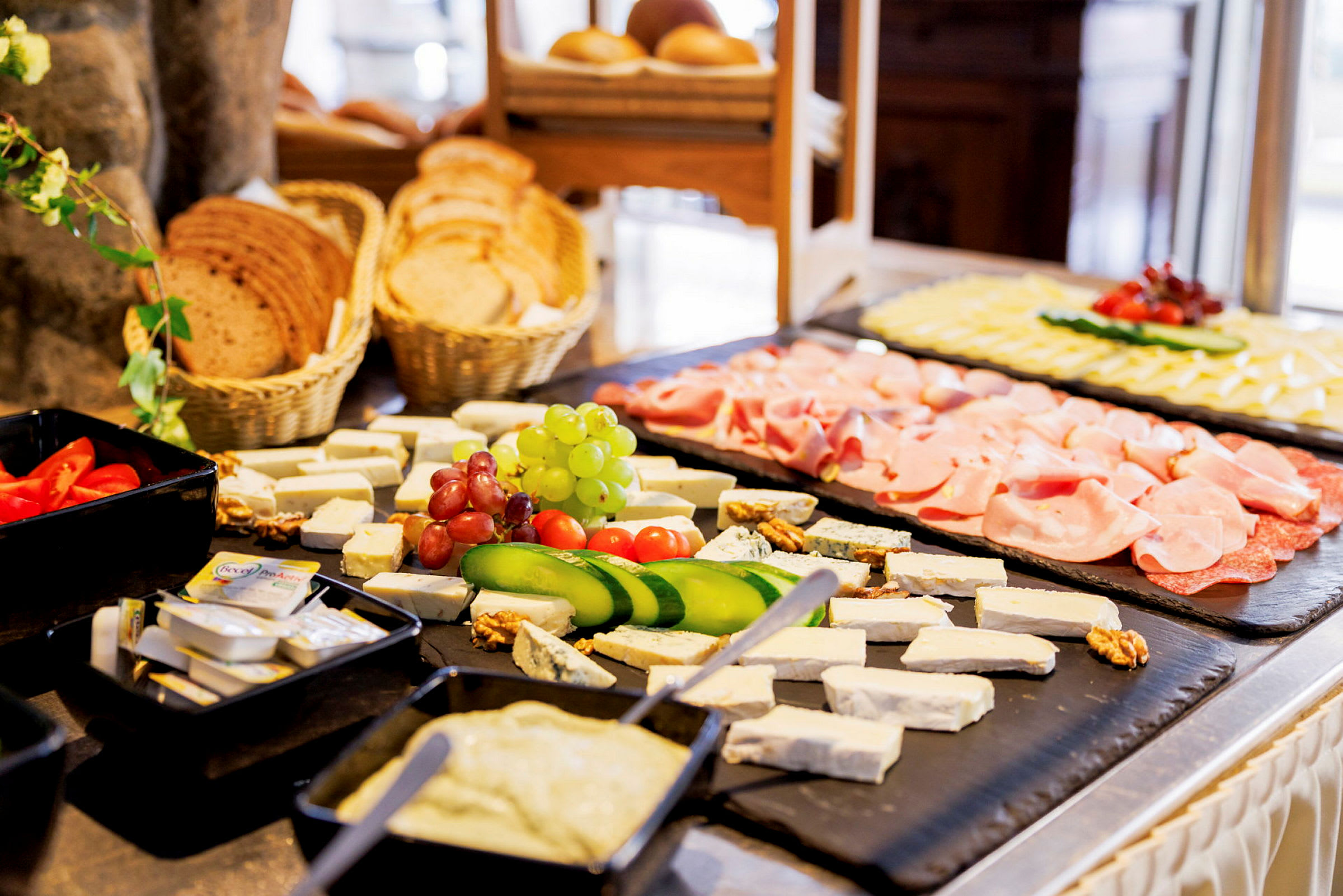 En buffé med olika matvaror inklusive ost, grönsaker, kött och bröd. (AI-genererad text)