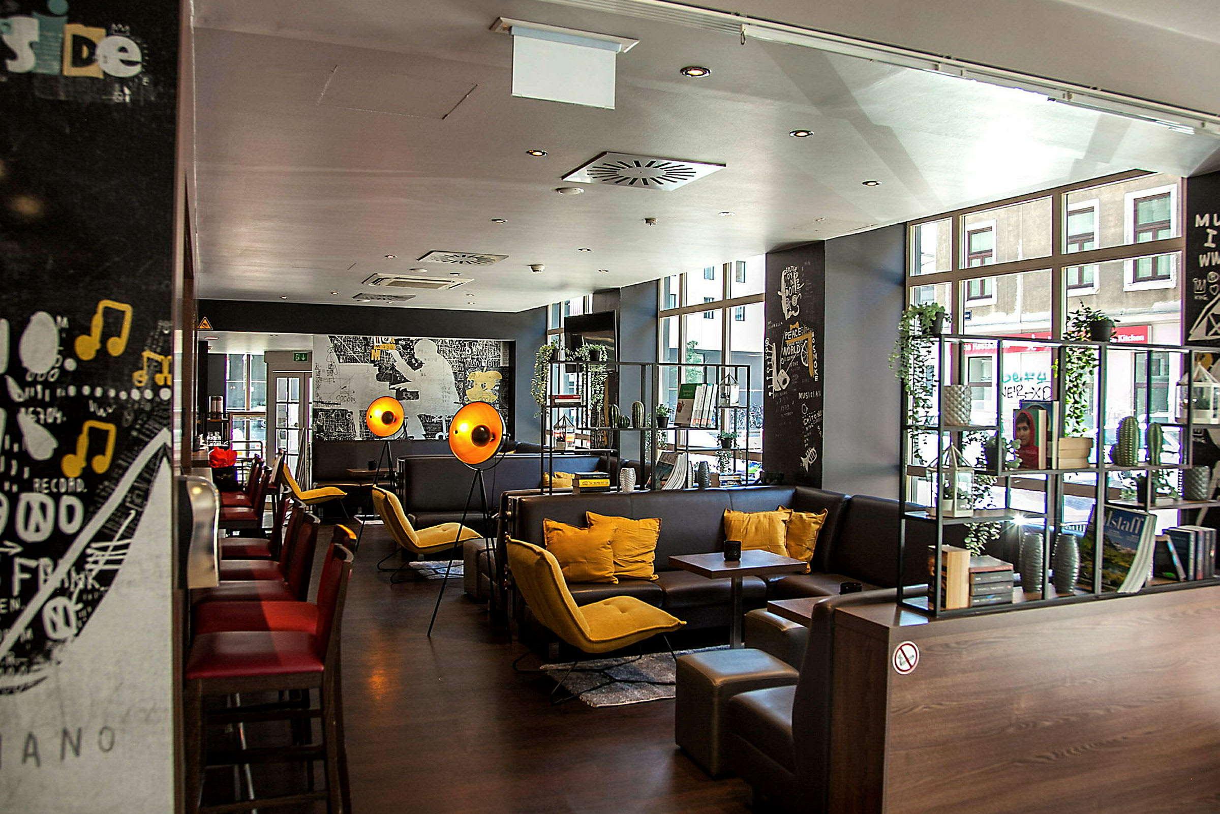 En modern restaurang eller kafé med sittgrupper, färgglada kuddar och dekorationer. (AI-genererad text)