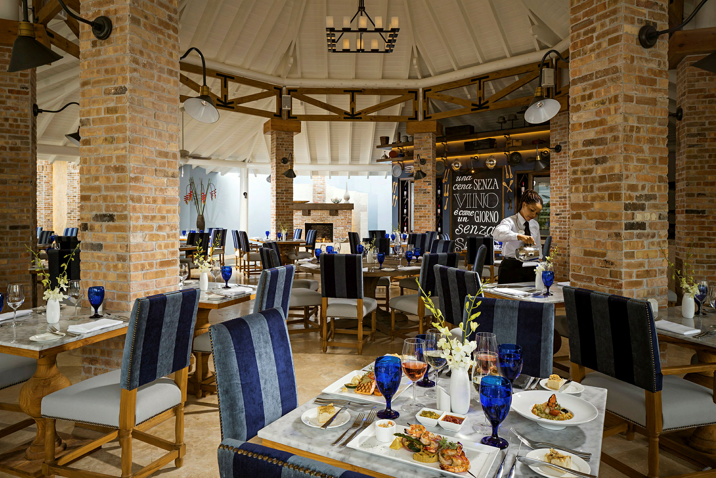 Interiör av en elegant restaurang med dukade bord och en tegelvägg. (AI-genererad text)