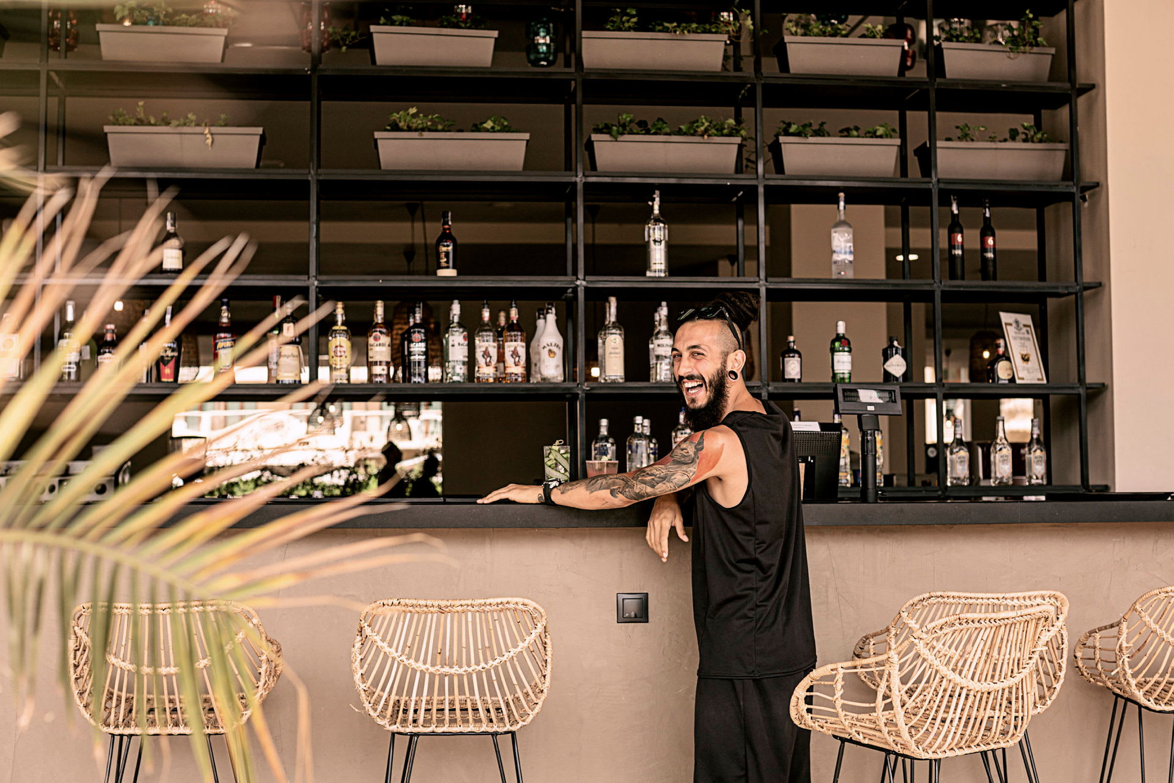 En elegant bar med flaskor, korgstolar och växtdekorationer. (AI-genererad text)