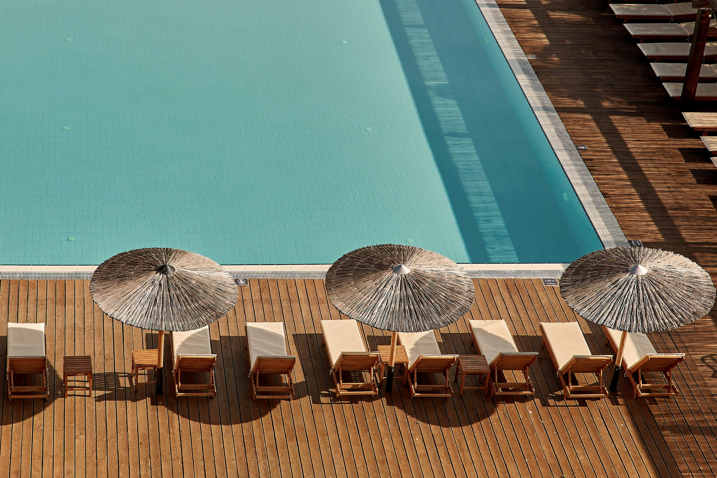 Solstolar och parasoller vid en pool. (AI-genererad text)