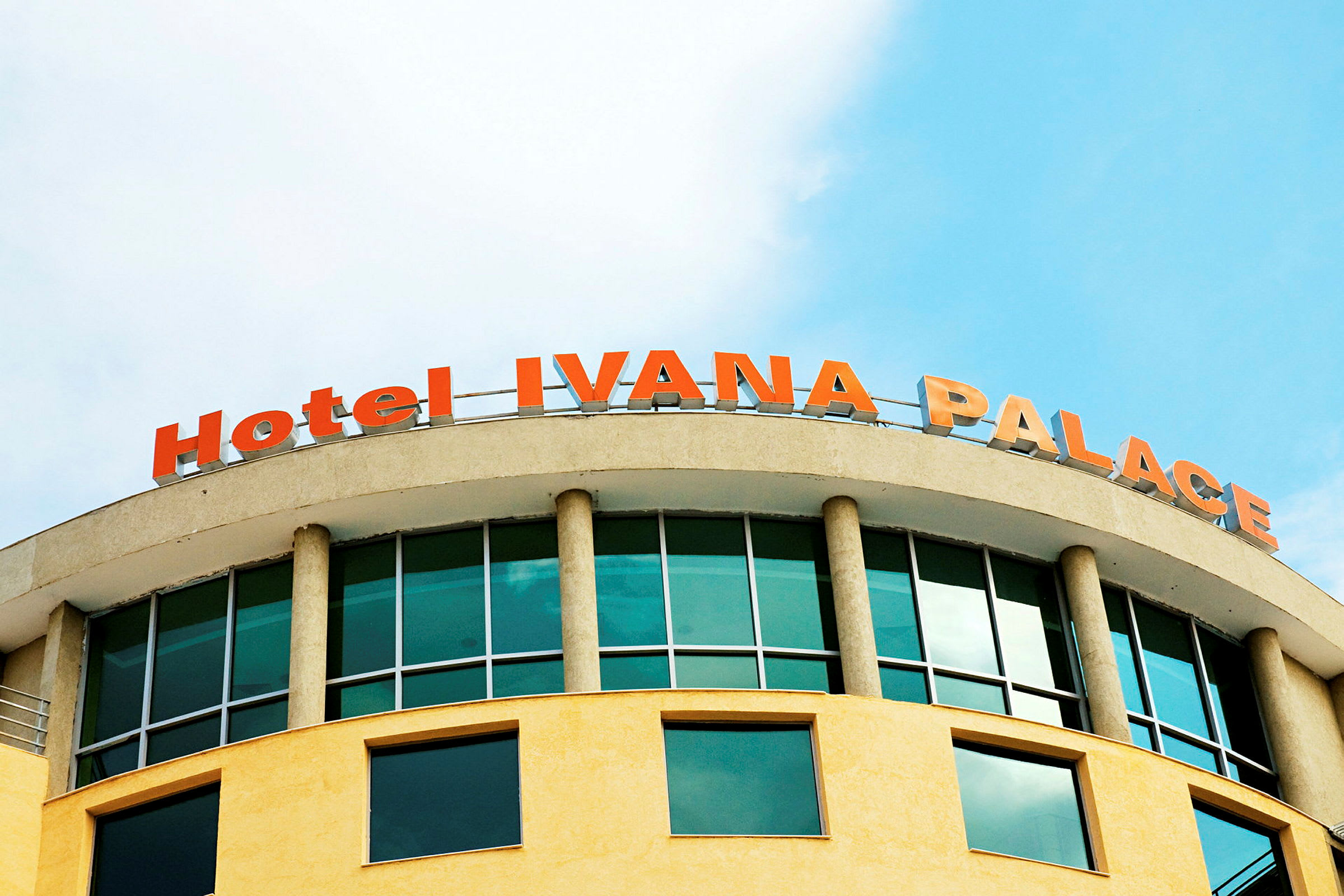 Bild av en byggnad med texten "Hotel IVANA PALACE" i rödorange på toppen. (AI-genererad text)