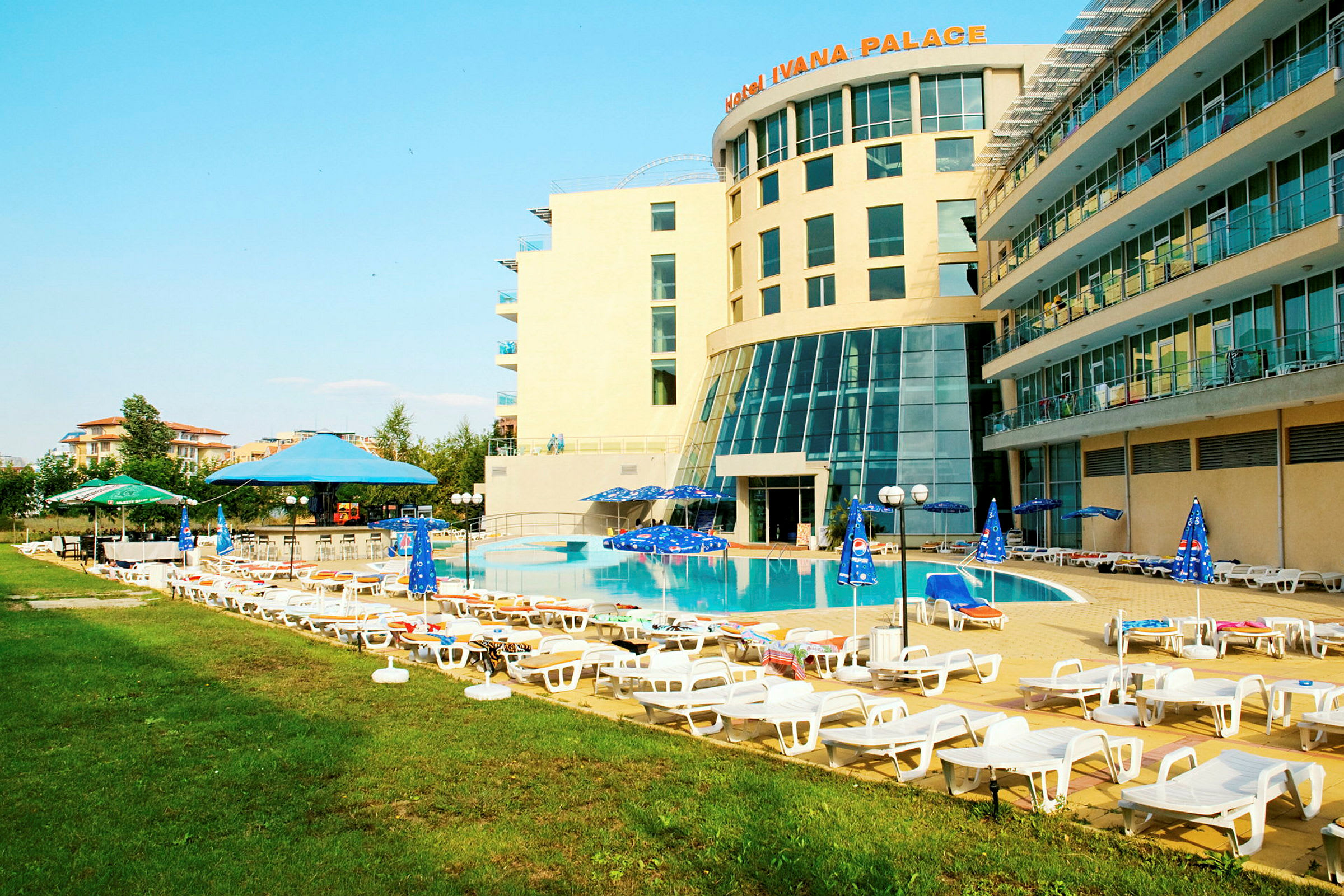 Hotellets poolområde med solstolar och parasoller. (AI-genererad text)
