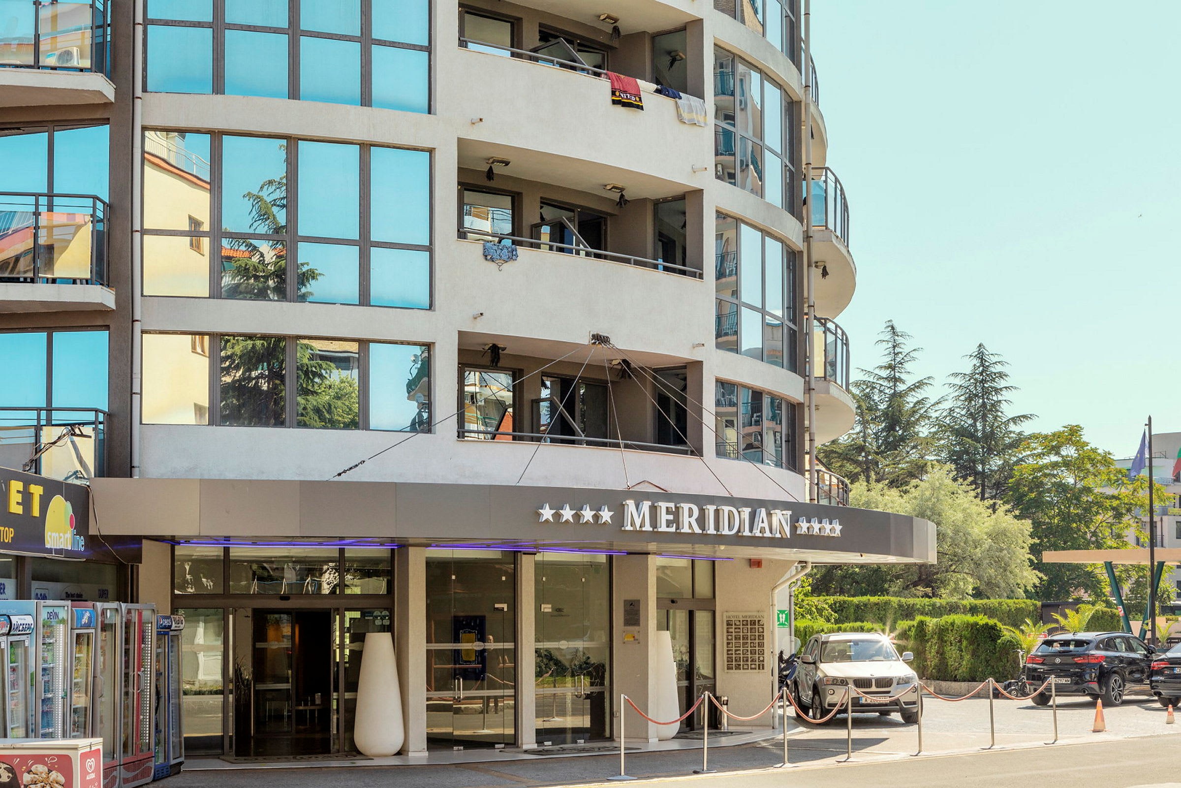 Ett hotell med glasfasad och texten 'Meridian' över entrén. (AI-genererad text)