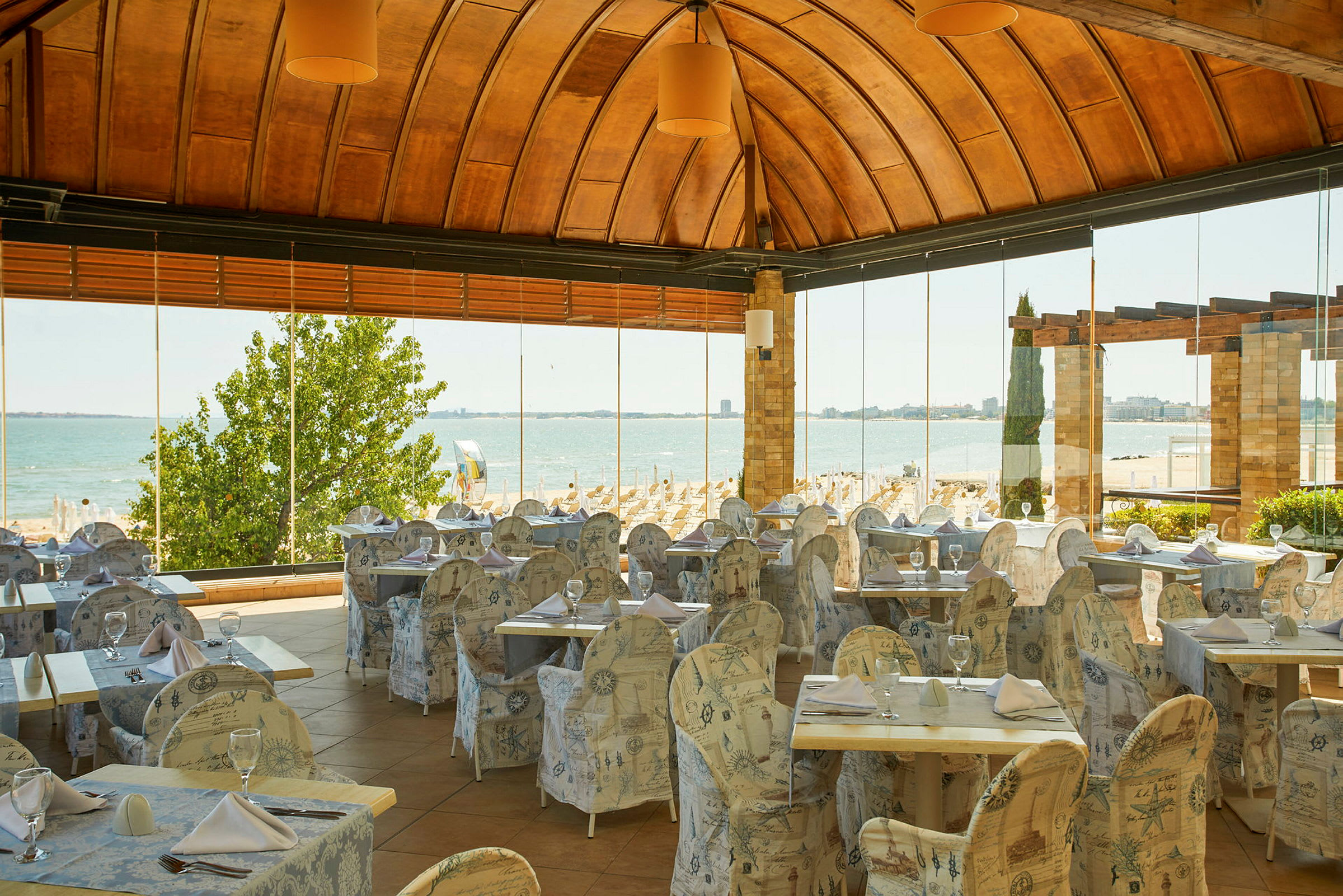 En restaurang med utsikt över en sandstrand och havet. (AI-genererad text)