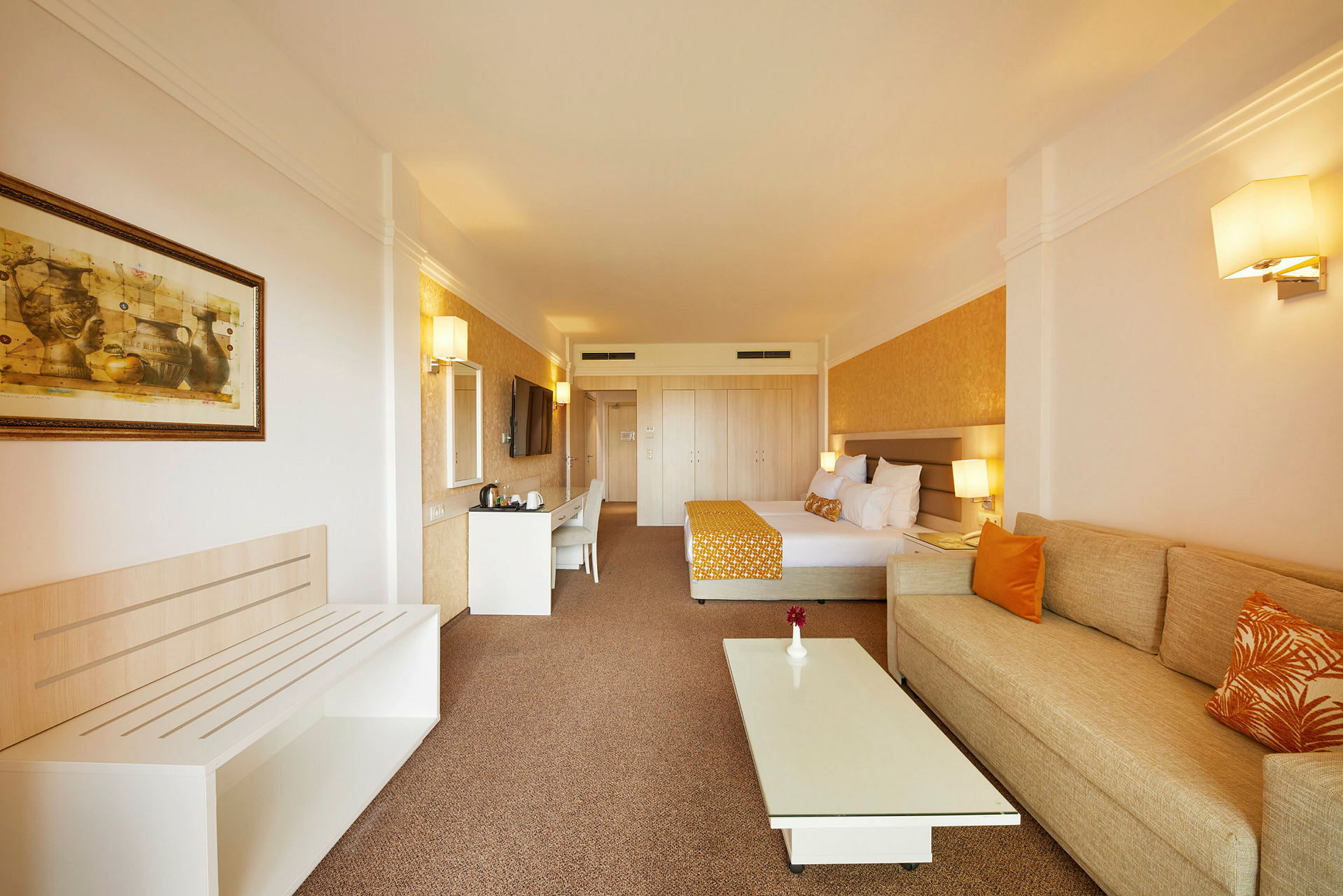 Inredning av ett hotellrum med säng, soffa och bord. (AI-genererad text)