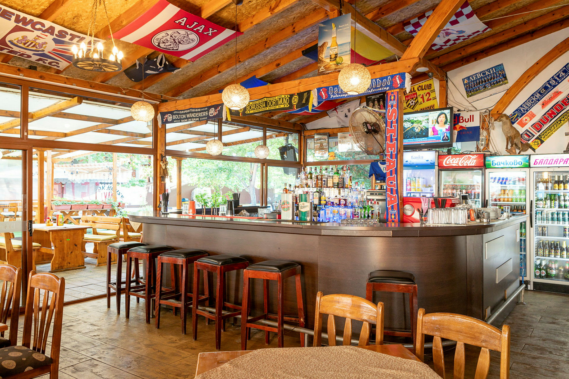 En välutrustad bar med sittplatser både vid bardisken och på uteserveringen under tak. (AI-genererad text)