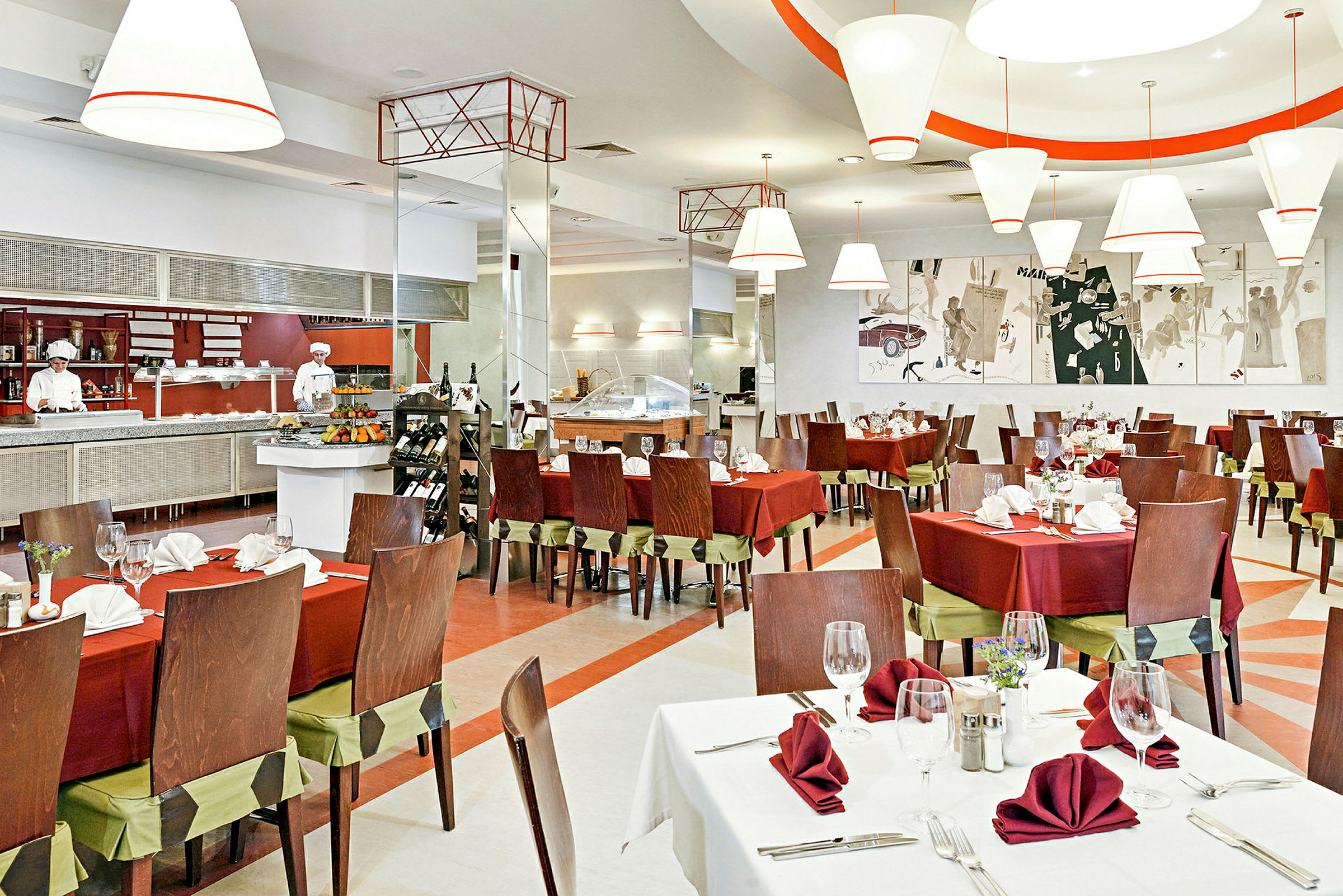 Bild på en elegant restaurang med bord prydda med röda dukar och servetter. I bakgrunden syns en öppen köksstation och konstverk på väggen. (AI-genererad text)