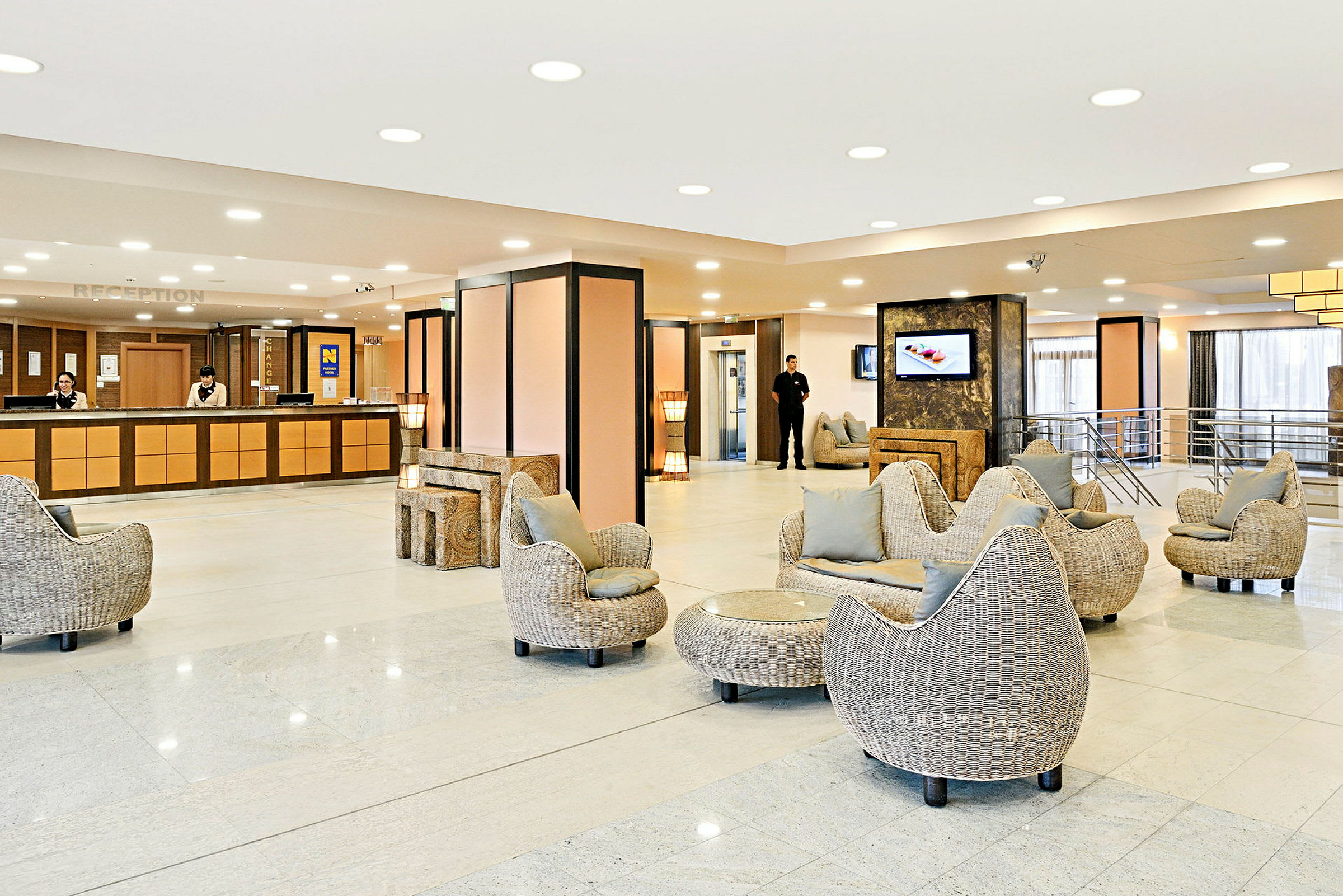 Hotellobby med receptionsdisk, sittgrupper, och ljusa moderna möbler. (AI-genererad text)