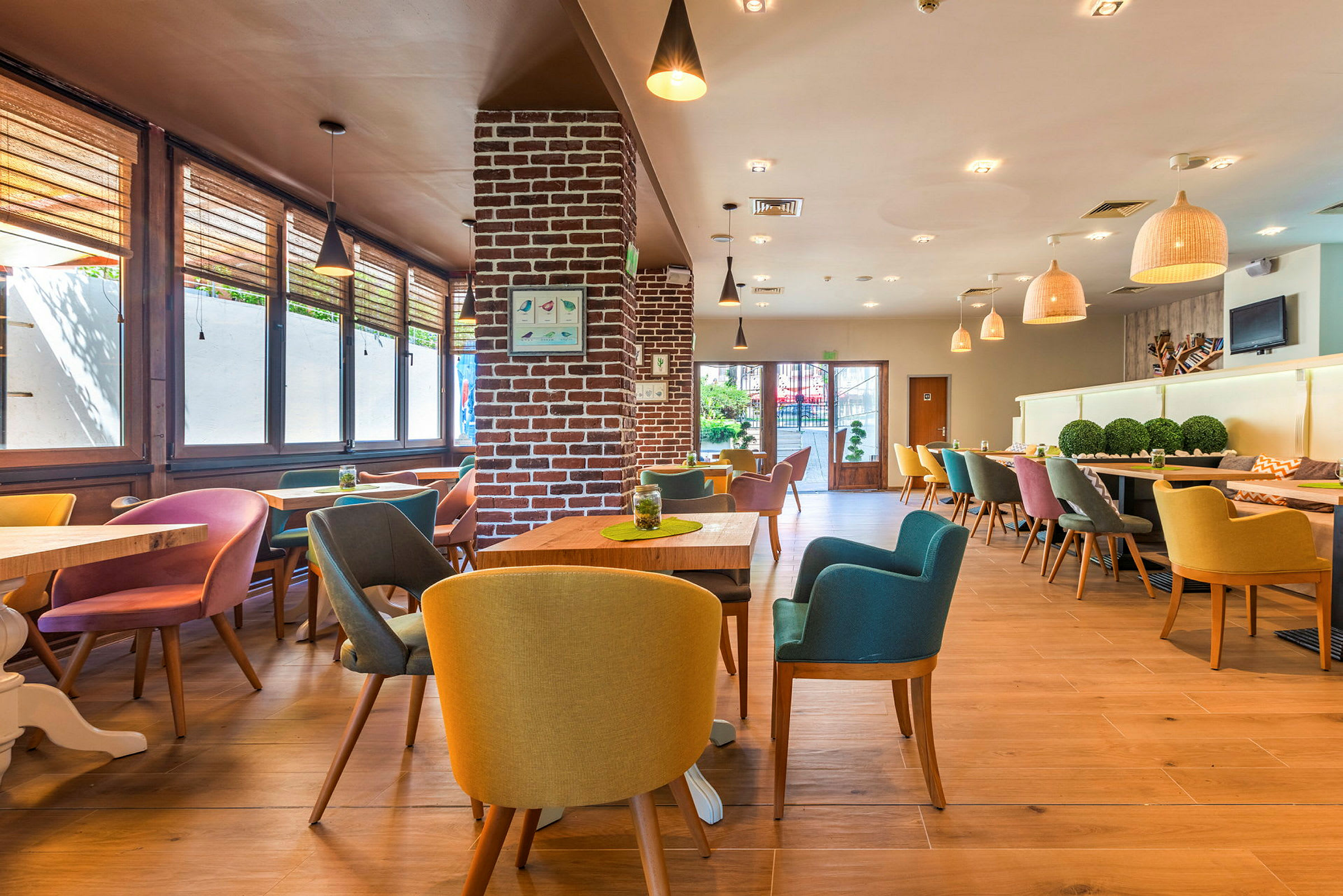 Interiör av en modern restaurang med färgglada stolar och träbord. (AI-genererad text)