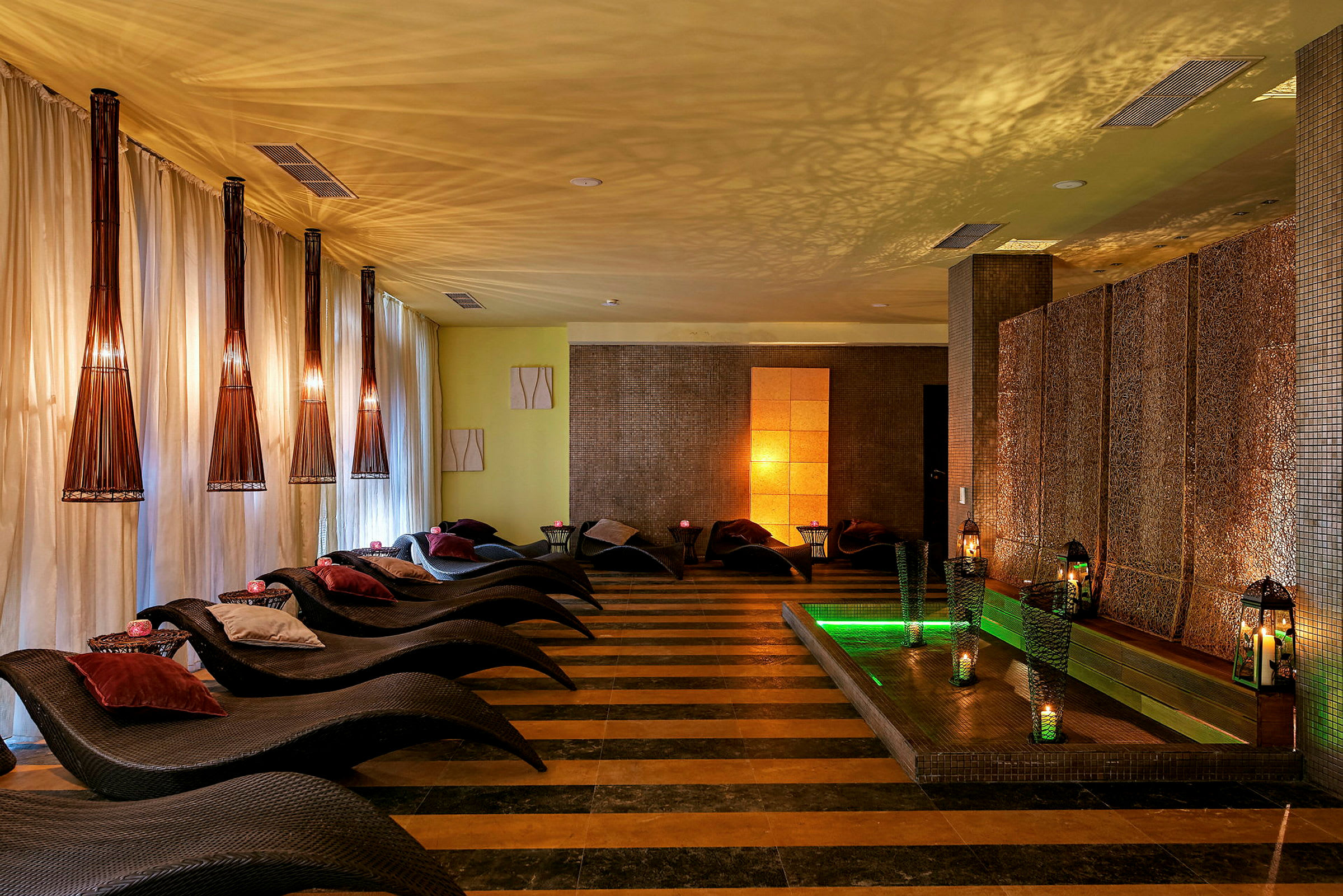 En avkopplande spa-lounge med vilstolar, mjuk belysning och dekorativa lyktor. (AI-genererad text)