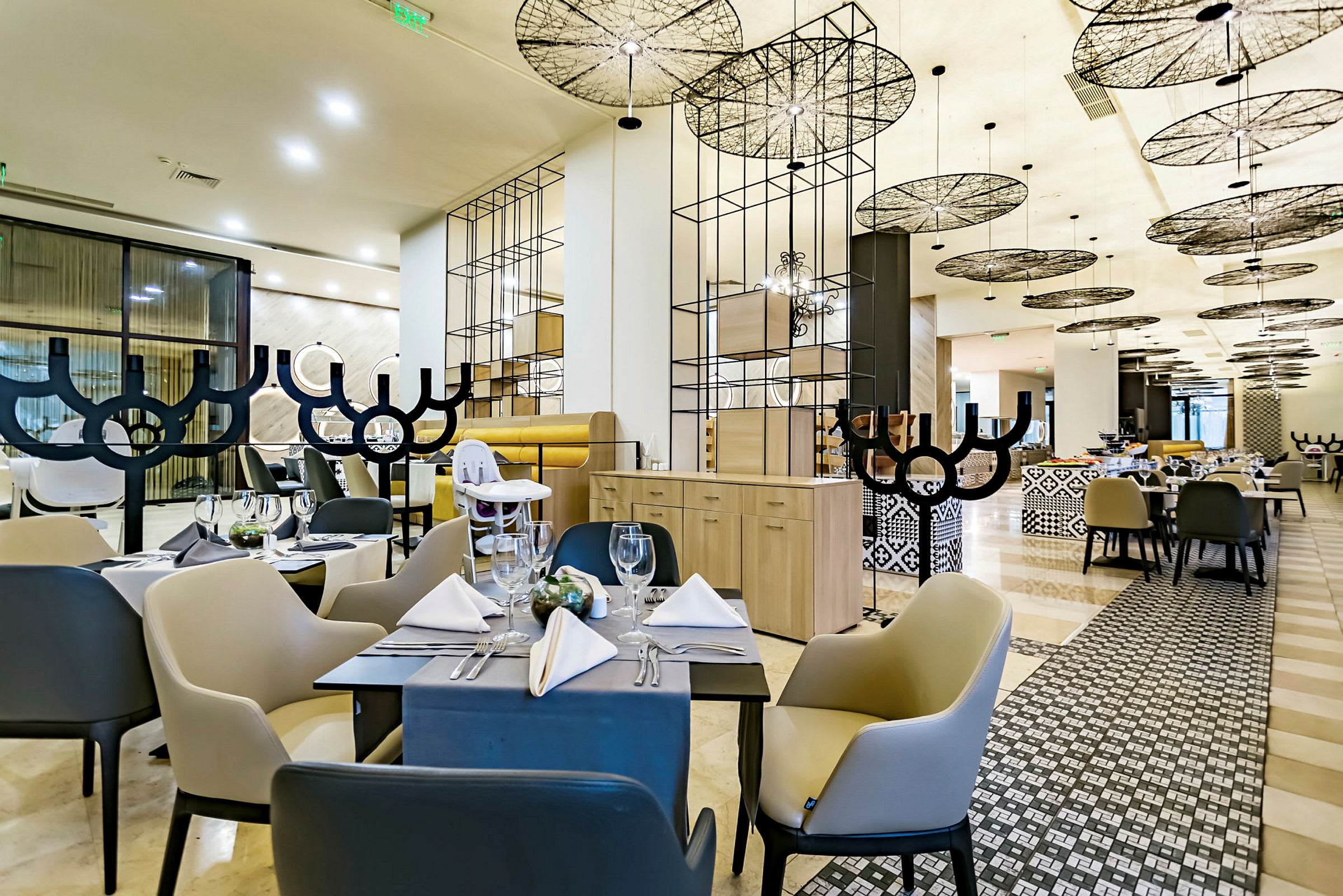 En modern restaurang med eleganta möbler och ett stilfullt tak. (AI-genererad text)